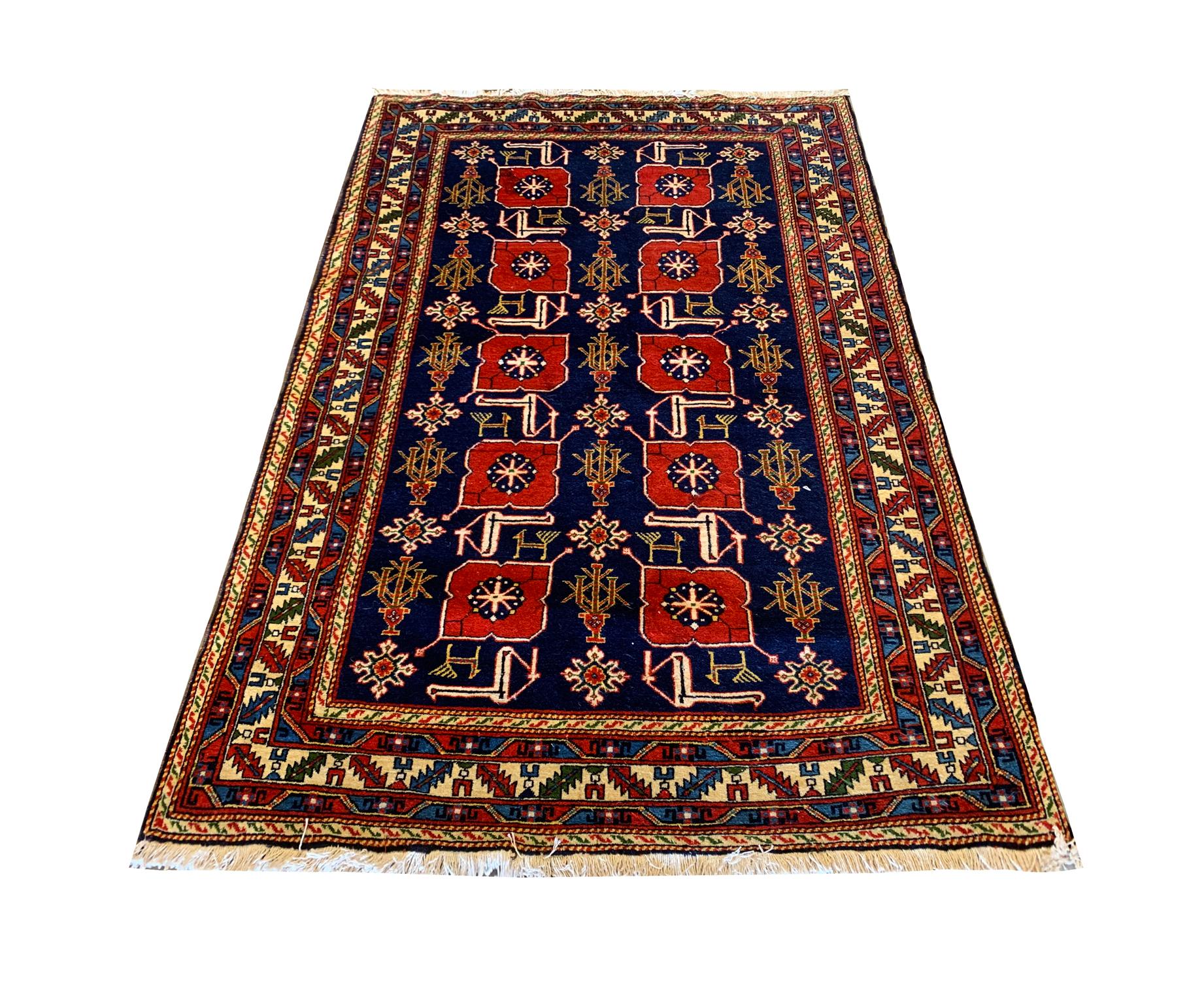 Blue and red make up the main colours in this fine wool Karakashli rug, woven by hand in Azerbaijan. This piece is collectable and features a deep blue background with a highly detailed pattern design woven in red, cream gold, and beige accents. The