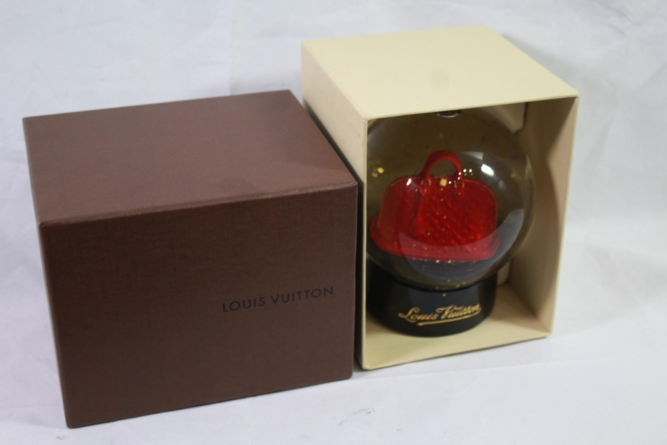 Lousi Vuitton red Alama Snow globe. 
Good condiiton but some scratches in the base. 
Sold with box.