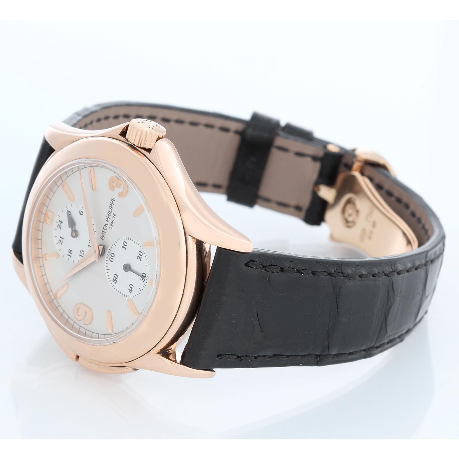 Collectible Patek Philippe Travel Time Men's 18k Rose Gold Watch 5134 R or 5134R - Manual winding; dual time. 18k rose gold case with exposition back (36mm diameter). Silver dial with rose gold raised numerals. Patek Philippe strap band; 18k rose 