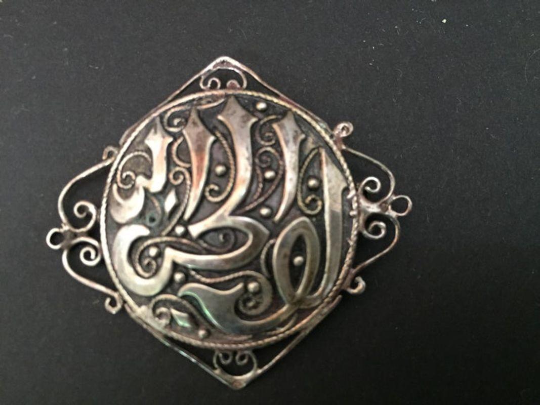 Stunning 1900s collectible Ottoman style Turkish silver brooch or veil pin with Arabic writing repousse.
Middle Eastern collectible sterling silver jewelry brooch pin in circular Arabic Islamic Calligraphy engraving.
Handcrafted antique sterling