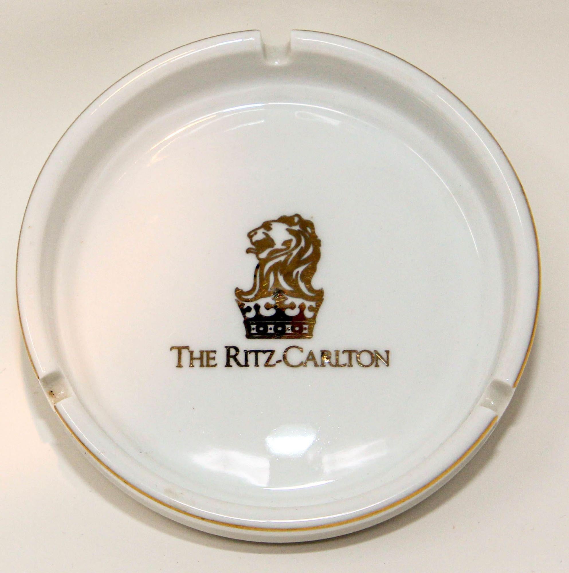 Collectible vintage The Ritz Carlton white and gold ashtray, catchall or jewelry Dish.
Vintage white and gold porcelain ashtray from the iconic 'The Ritz Carlton' hotel, circa 1970's.
Iconic lion and crown logo in gold at center. 
Great for its