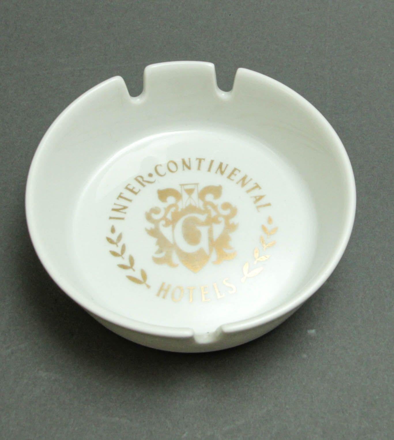 Collectible Ashtray Inter-Continental Hotel Geneve Switzerland.
From the Luxe Resort in Geneve, Switzerland, collectible white porcelain ashtray.
White porcelain with gold Imperial crown logo and inscriptions.
Diameter: 4.25 inches x 1.25