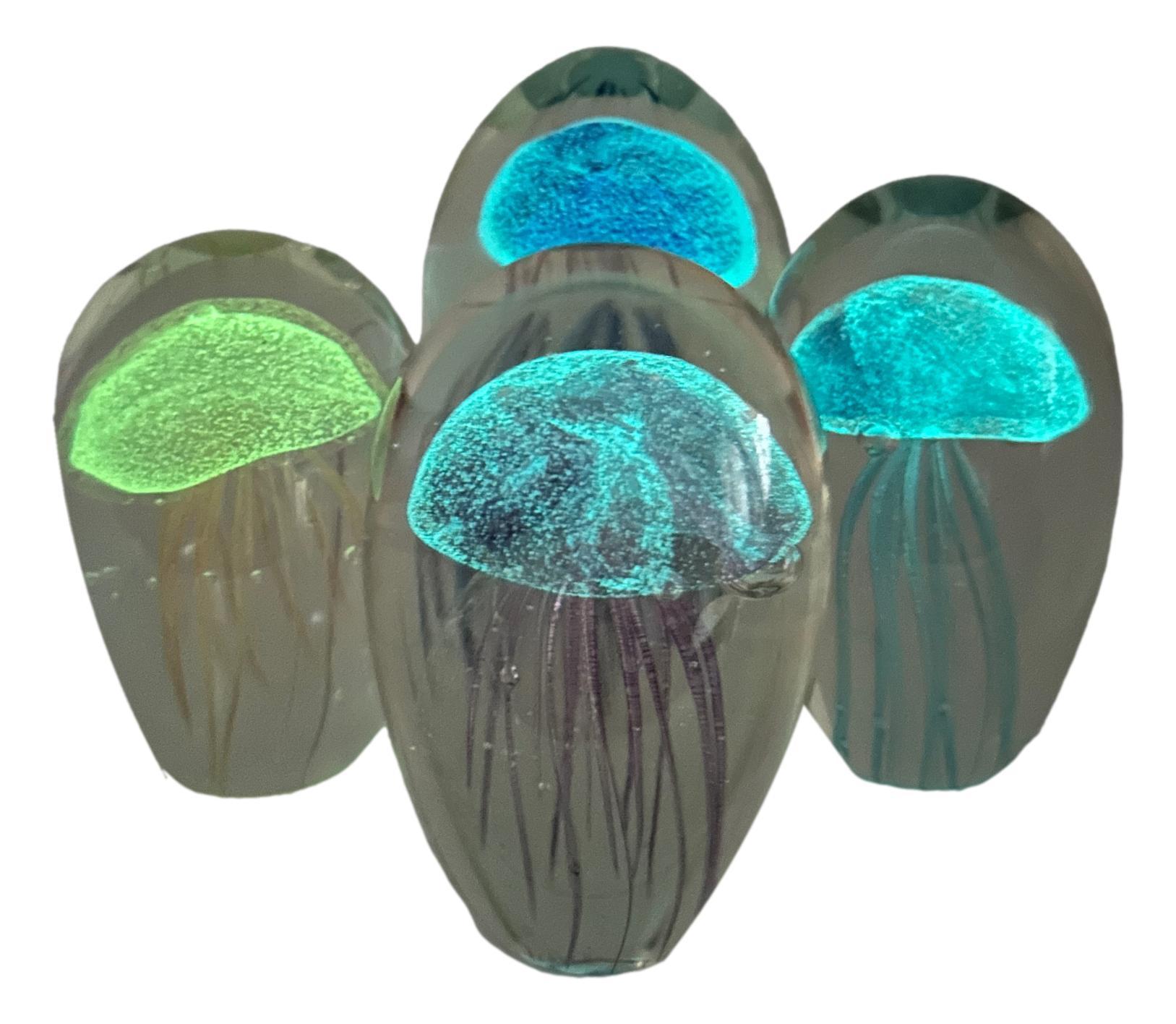 Beautiful set of four Murano hand blown aquarium design Italian art glass paper weights or statues. Showing Jelly Fish inside, in different colors, floating on controlled bubbles. Colors are a blue, light blue, purple and yellow. 

After they're