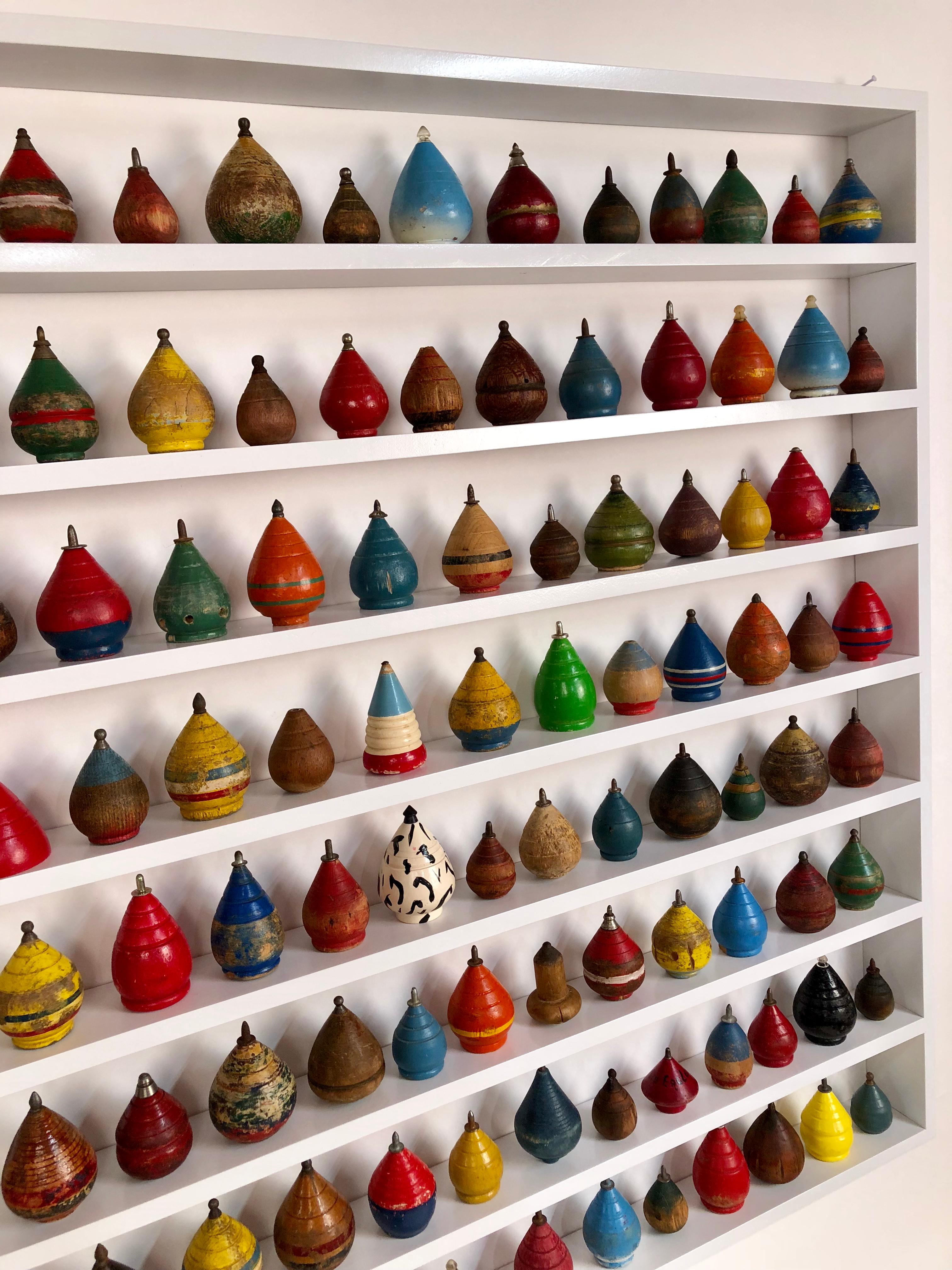 Collection of 100 antique spinning tops in a custom shadow box frame.