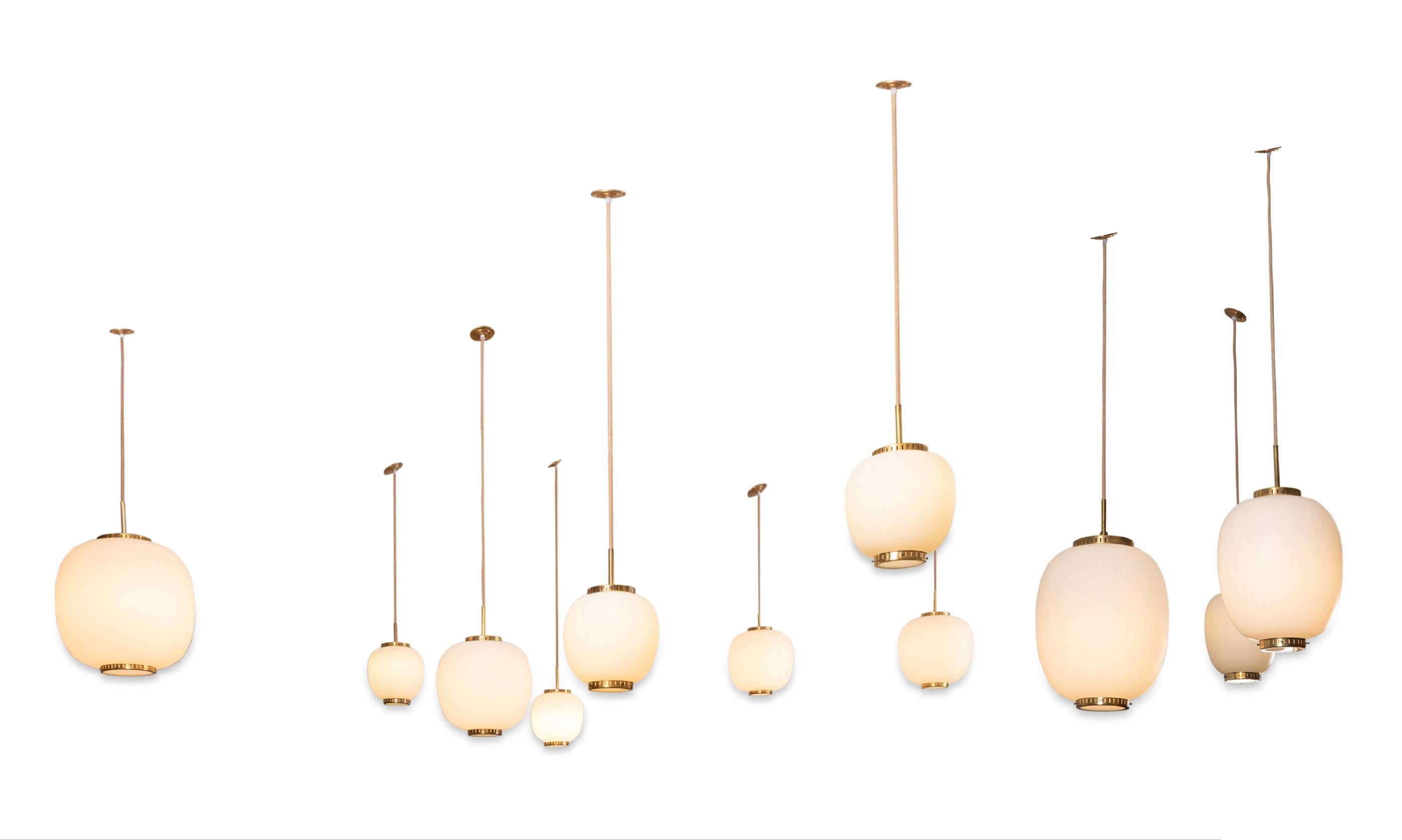 Collection of 11 opaline glass and brass ceiling fixtures.
See dimensions below
Designed by Bent Karlby for Lyfa.
Denmark, late 1950s.

Dimensions: (Height of the opaline + top and bottom brass discs)
 Very large (1 item available): H 15.7 in.