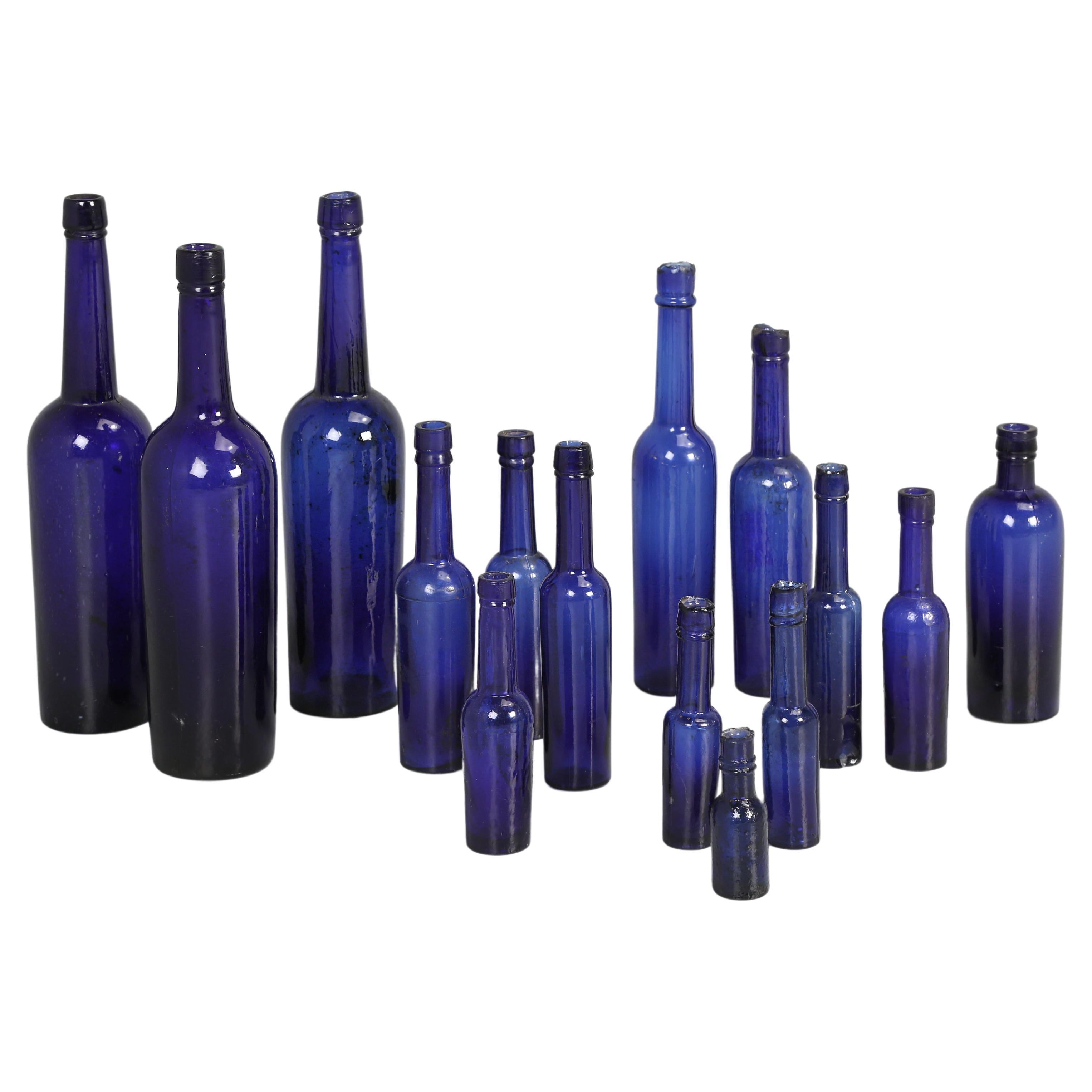 Collection de (15) bouteilles à huile en fonte bleu cobalt soufflées à la main fabriquées dans les années 1800 