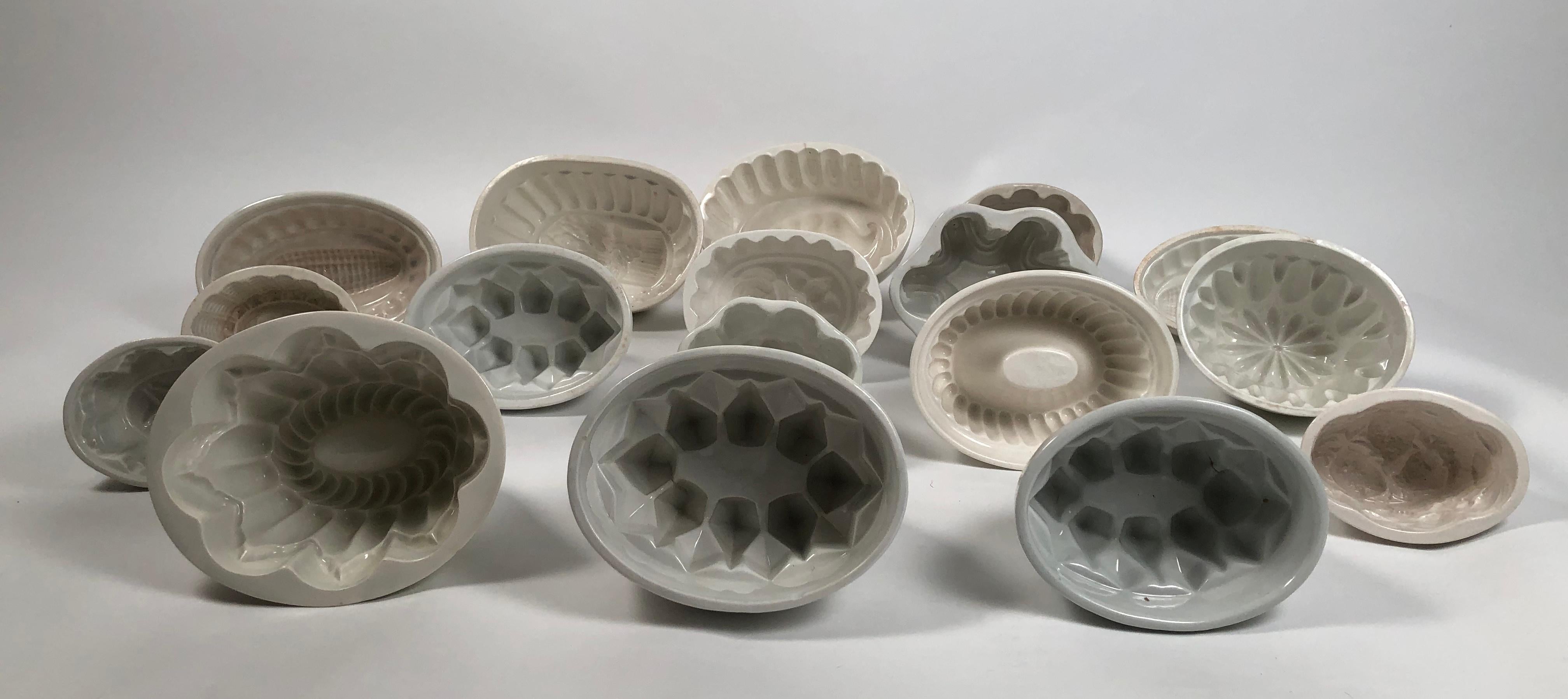 A large collection of 17 geometric English white ironstone pudding molds of various shapes and sizes. These were used for making sculptural culinary specialties--mousses, aspics, steamed puddings, etc. Wonderfully graphic and varied, these stoneware