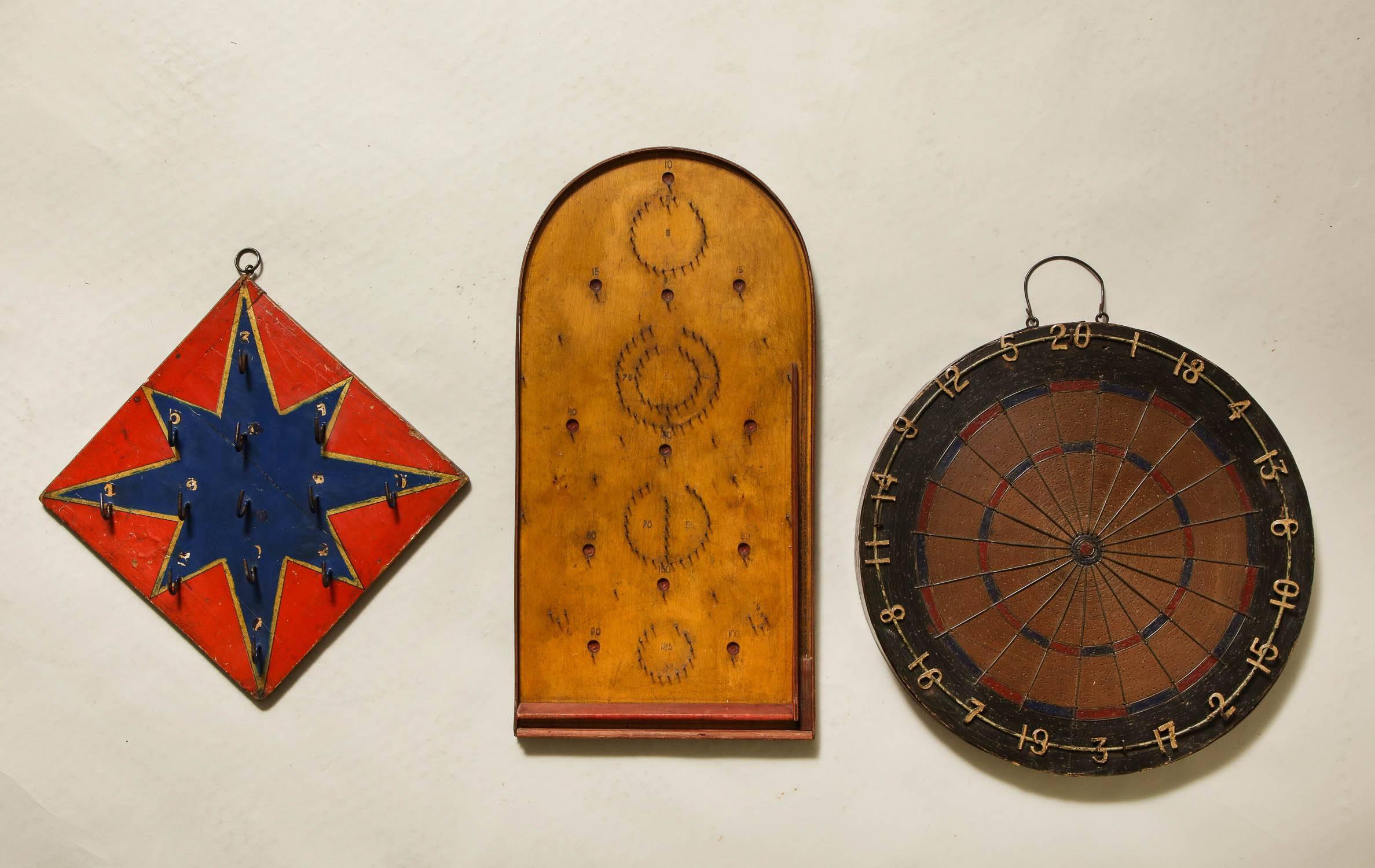 Charming group of three 19th century games comprising a dartboard, star ring toss and bagatelle boards, all in original paint and possessing both whimsy and good graphic design.

Size listed below for dartboard. Other sizes in additional