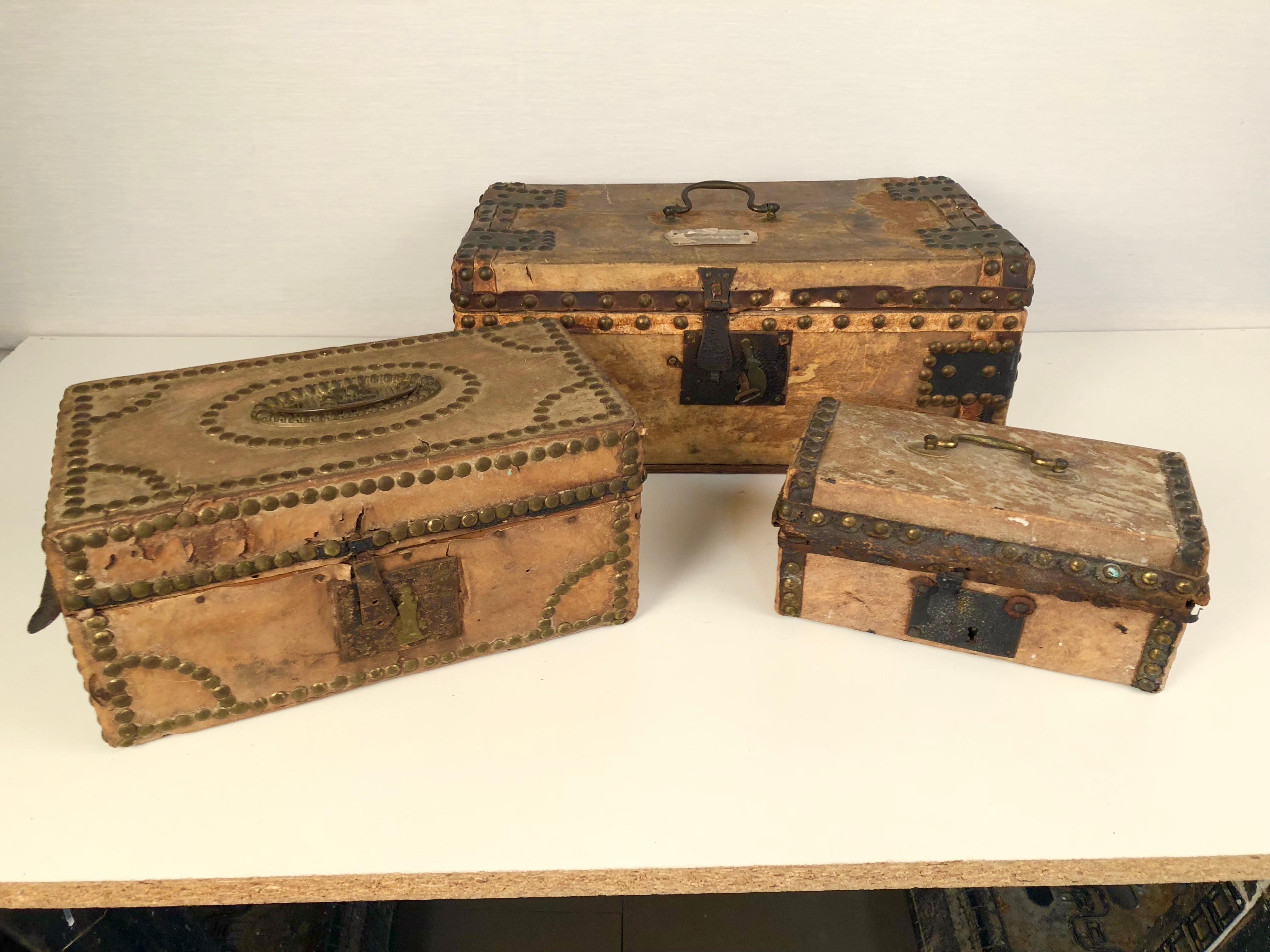 A collection of three 18th century parchment covered boxes with nailhead decoration and brass handles, the largest retaining its original key, European.