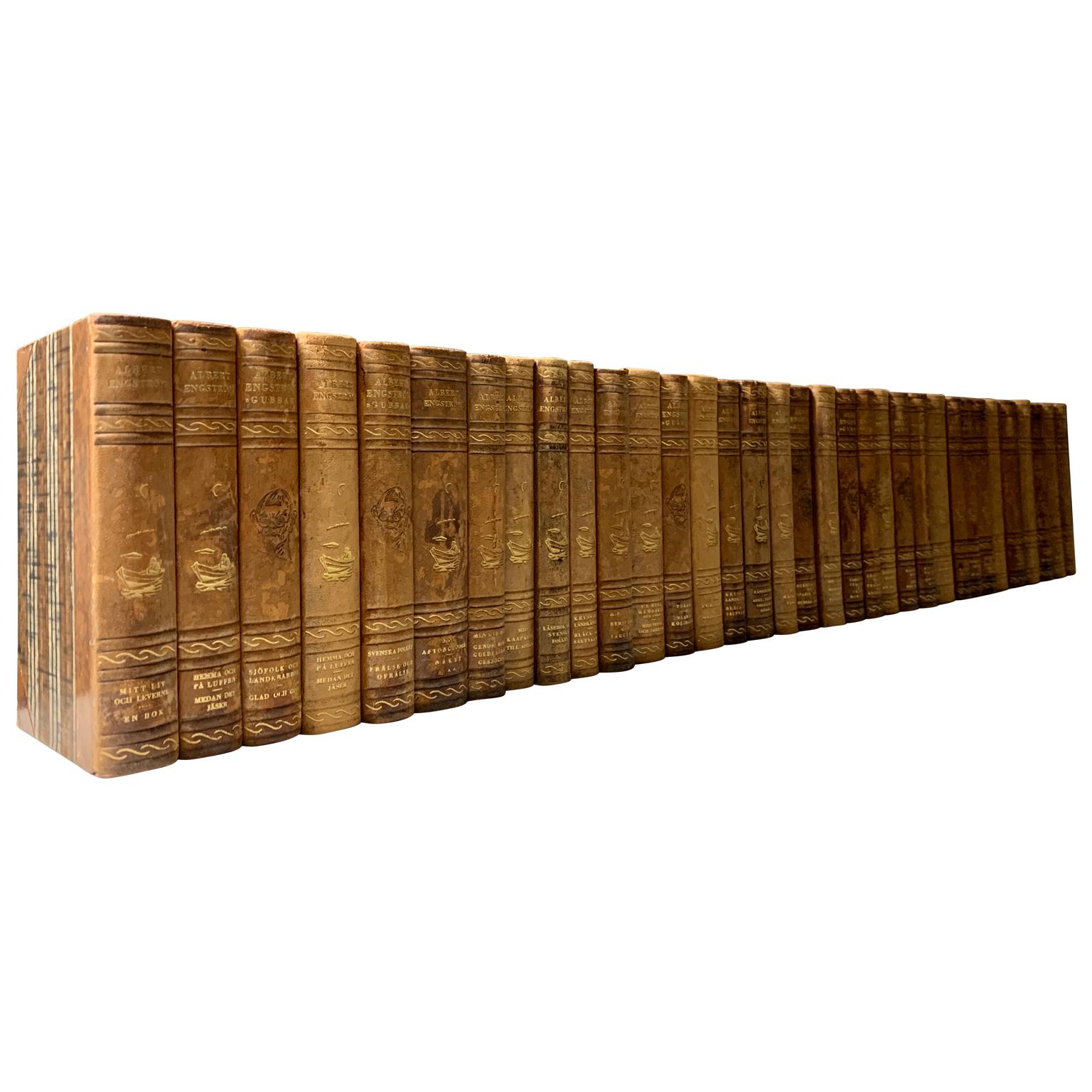 A collection of 34 Swedish decorative antique leather-bound library books.
The books are wrapped in leather-bound covers, comprised of a selection of warm tones and gold leaf print embossing.
The book collection measure horizontally is 1,04 m,