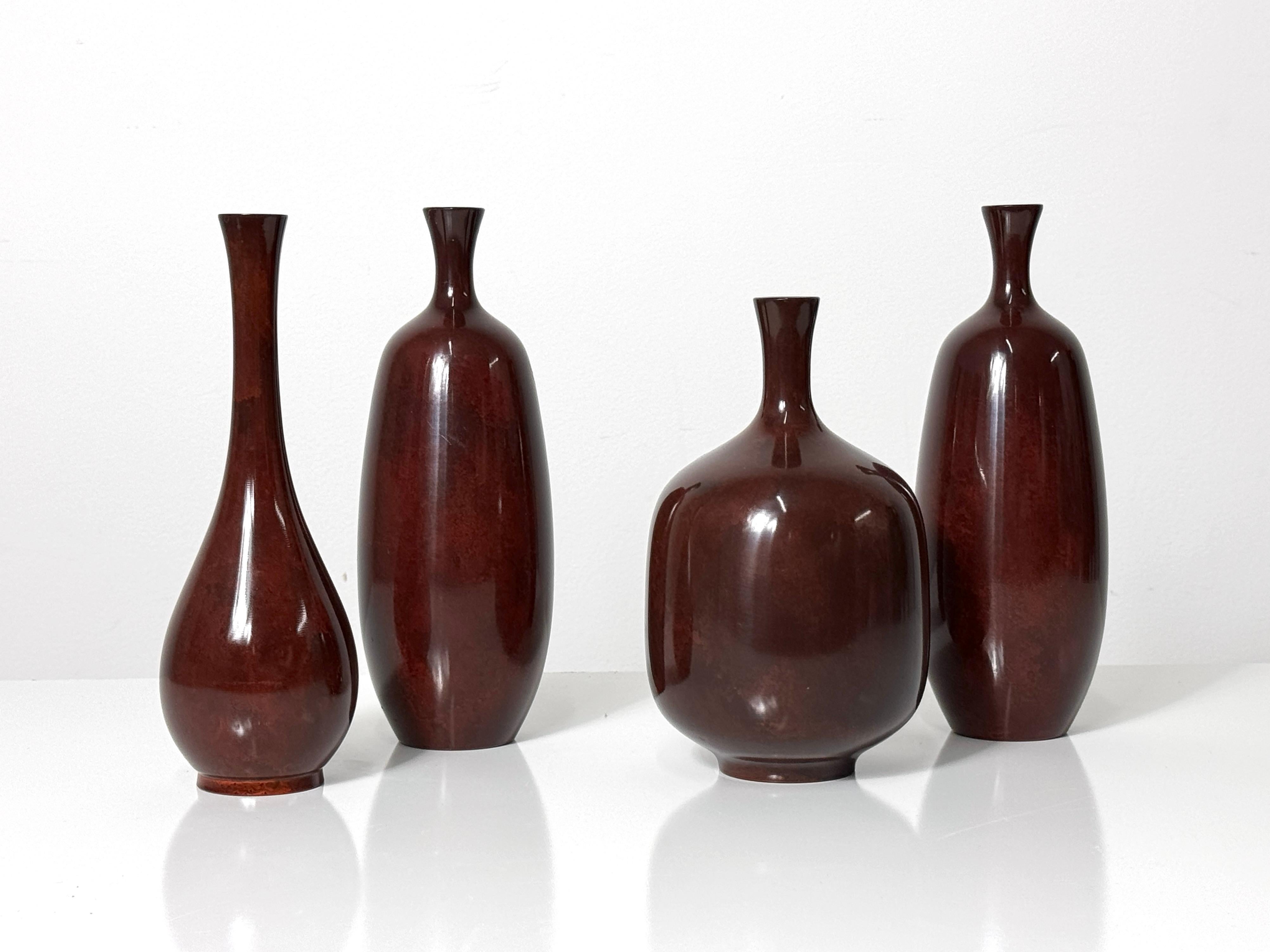 Gruppe von vier Vintage-Bronzevasen Japan ca. 1950er Jahre

Ein feines Arrangement aufeinander abgestimmter patinierter Knospenvasen in Form einer Flasche in gesprenkelter, tief ochsenblutfarbener Färbung 

Die Abmessungen variieren mit Durchmessern