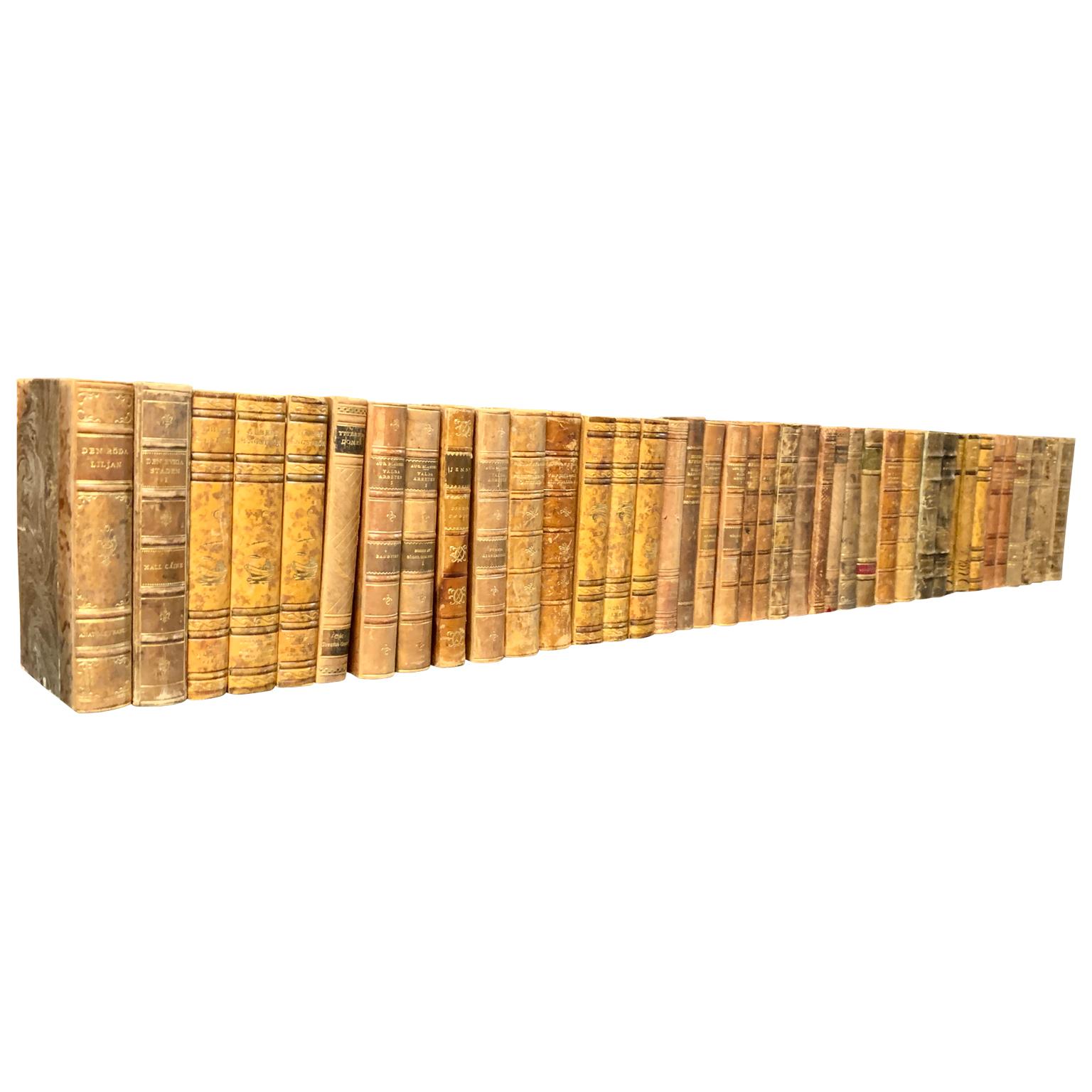 A collection of 40 Swedish decorative antique leather-bound library books.
The books are wrapped in leather-bound covers, comprised of a selection of warm tones and gold leaf print embossing.
The book collection measure horizontally is 1, 23 m,