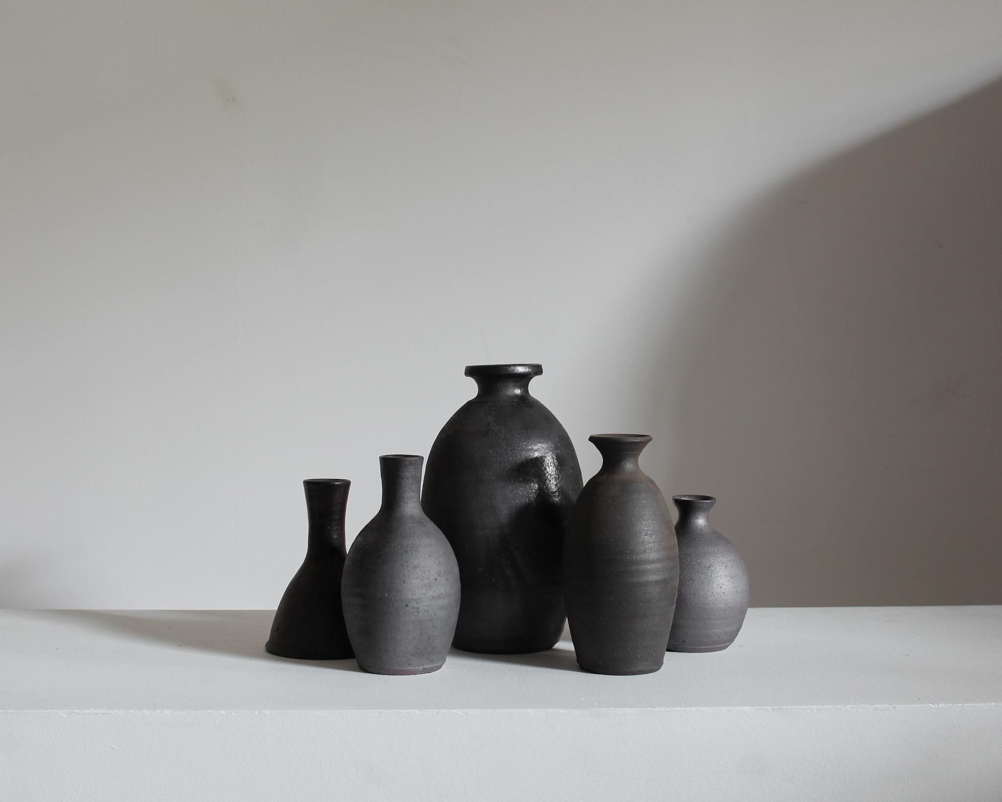 A collection of five unique blackened stoneware/ceramic vessels from the famous pottery town of Mashiko, Japan.

Sourced from the former studio of a Mashiko lifetime potter.

These tactile vessels all display an earthy wabi-sabi aesthetic.

Most of