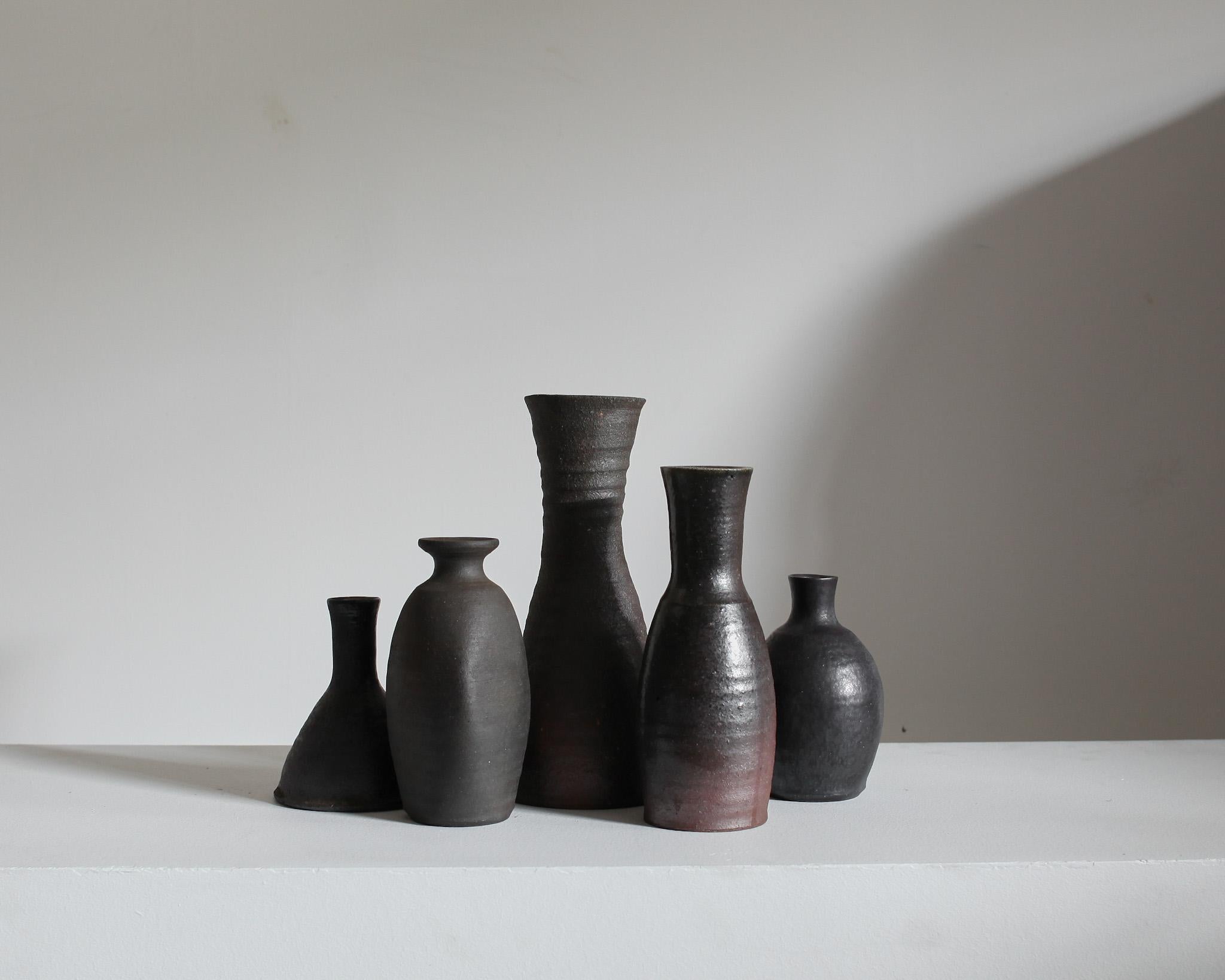 A collection of five unique blackened stoneware/ceramic vessels from the famous pottery town of Mashiko, Japan.

Sourced from the former studio of a Mashiko lifetime potter.

These tactile vessels all display an earthy wabi-sabi aesthetic.

Most of