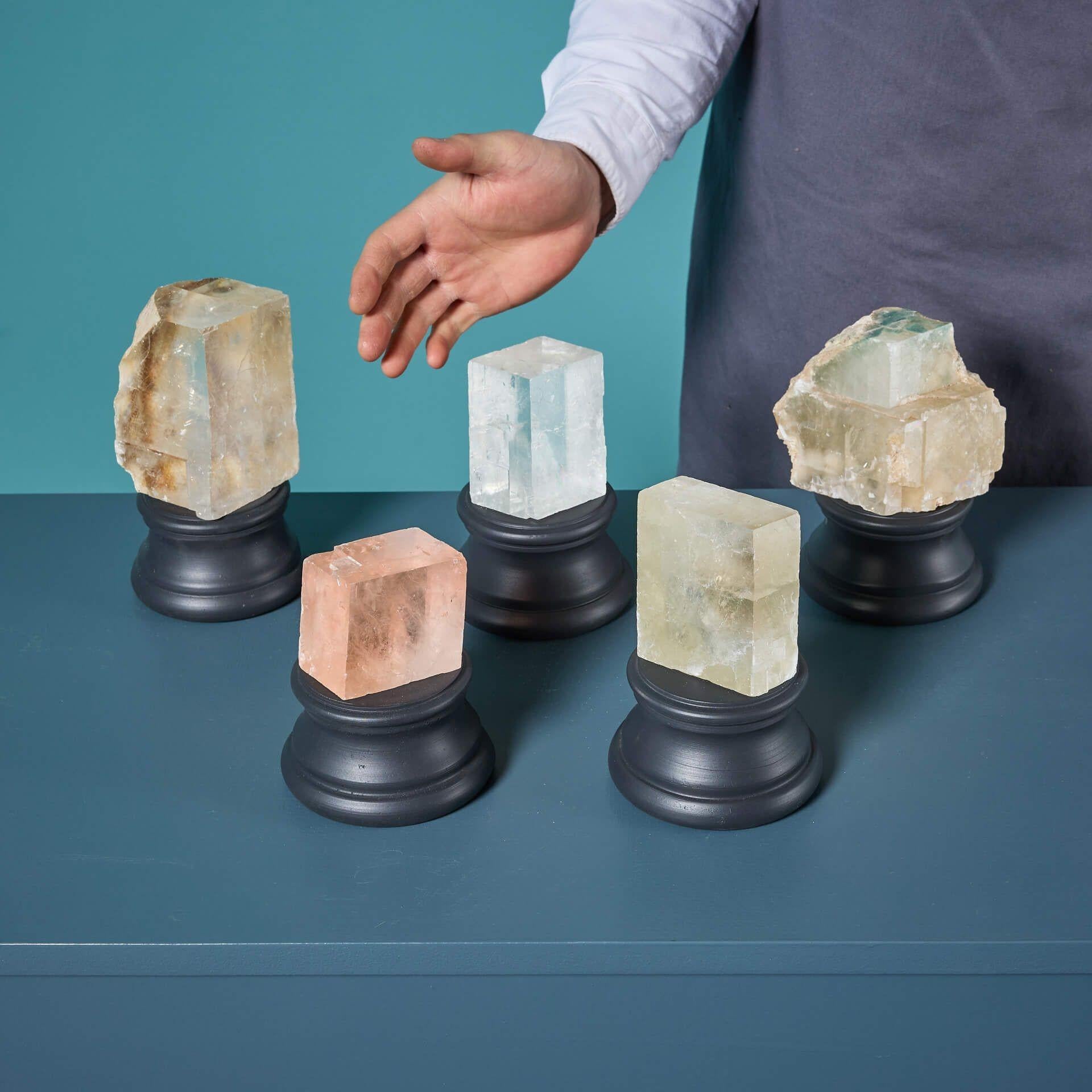 Una variada colección de 5 especímenes minerales naturales, cada uno presentado en una exclusiva base expositora pequeña.

Procedentes de diversos países, entre ellos China, este grupo contiene tres ejemplares de calcita óptica romboédrica de tonos