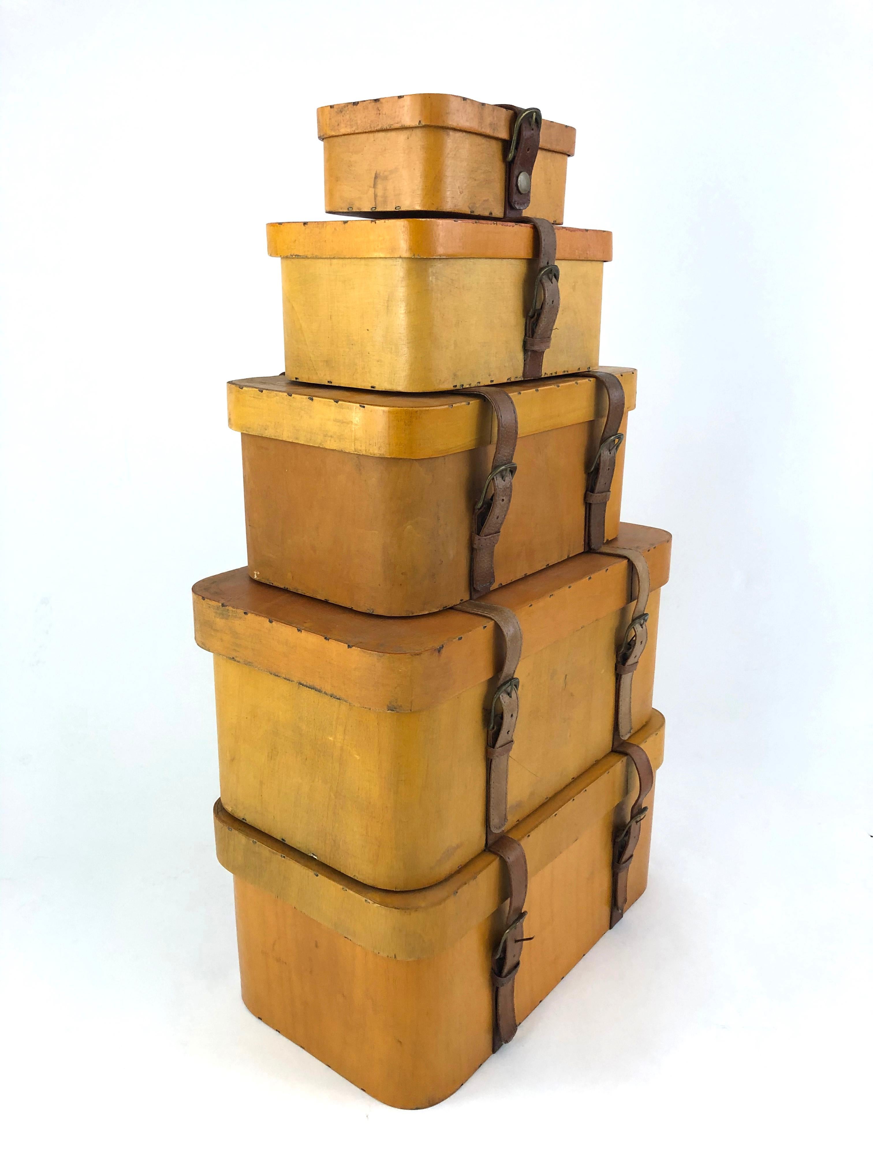 A collection of 5 vintage stacking bentwood birch and leather suitcases, of rectangular form with rounded corners, in graduated sizes. Each with a leather strap and metal buckles, circa 1950s, probably Baltic or Russian. These make for a striking