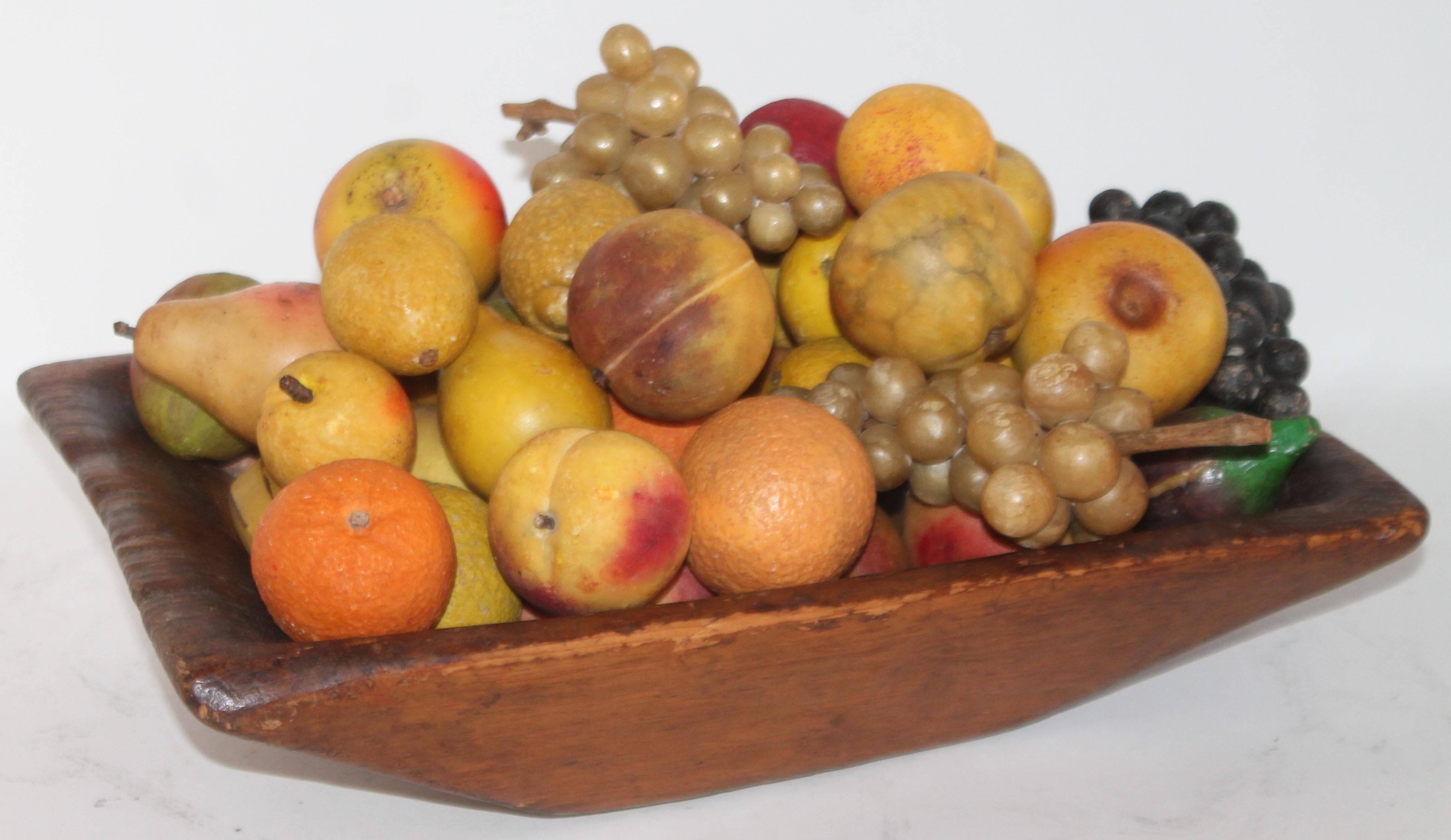 This 19th century hand carved dough bowl from New England is filled with a one man’s private stone fruit collection. All early original painted 50-piece stone fruit collection.