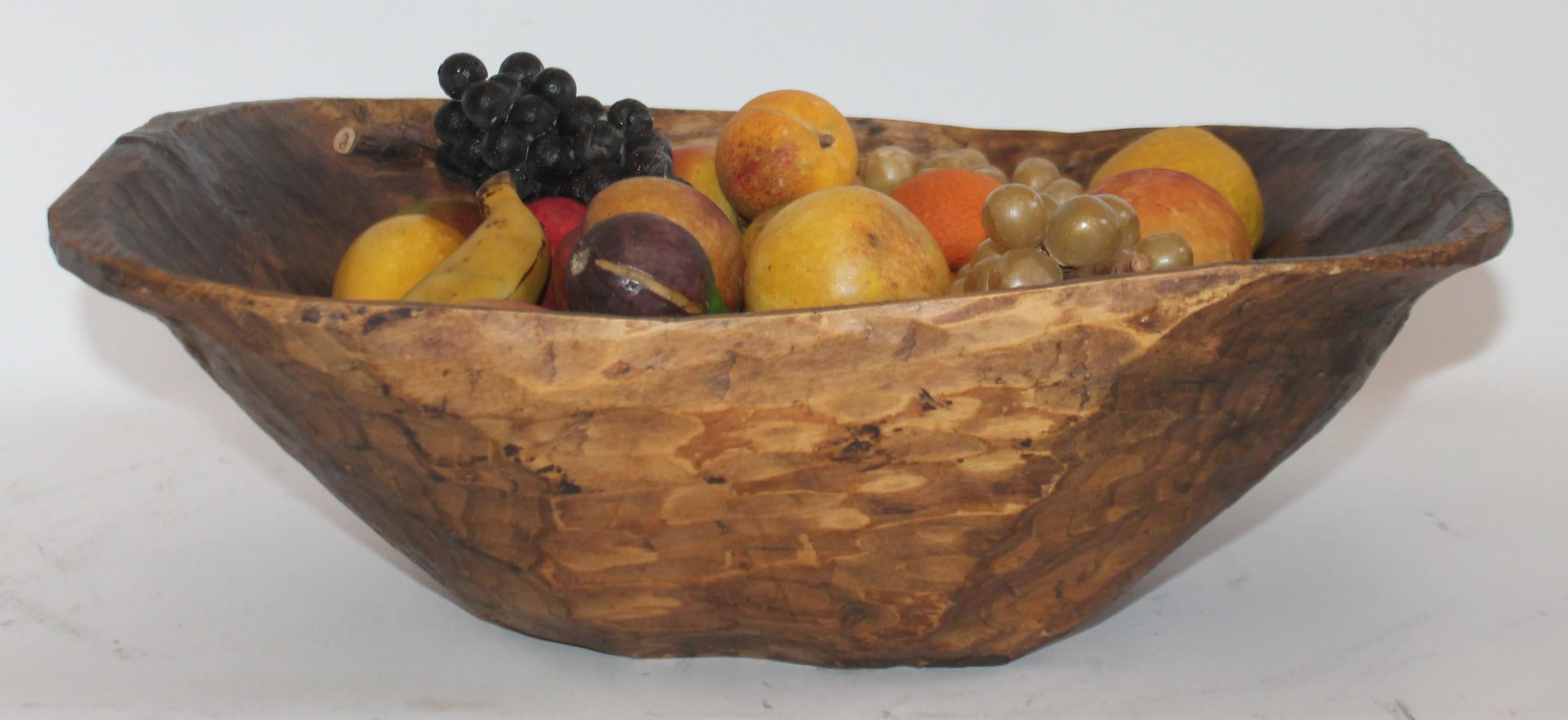 This 19th century hand carved dough bowl from New England is filled with a one man’s private stone fruit collection. All early original painted 50-piece stone fruit collection.