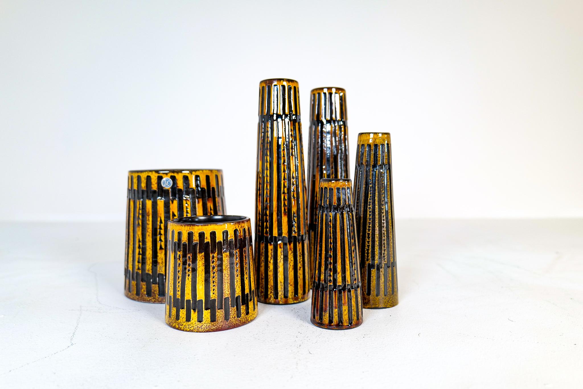 Wonderful midcentury vases and platter produced by Upsala Ekeby Sweden designed by Ingrid Atterberg 1962. The relief pattern gives life and structure to the yellow / brown glaze. 

Very good vintage condition. Small traces of wear on the