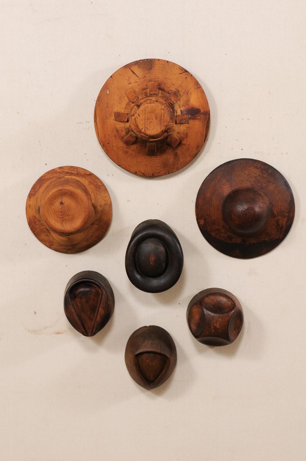 A collection of seven Italian wooden hat maker's forms from the turn of the 19th and 20th century. This set of antique carved wooden hat makers (or milliner's) hat forms from Italy includes seven individual molds, each varying in shape and size.