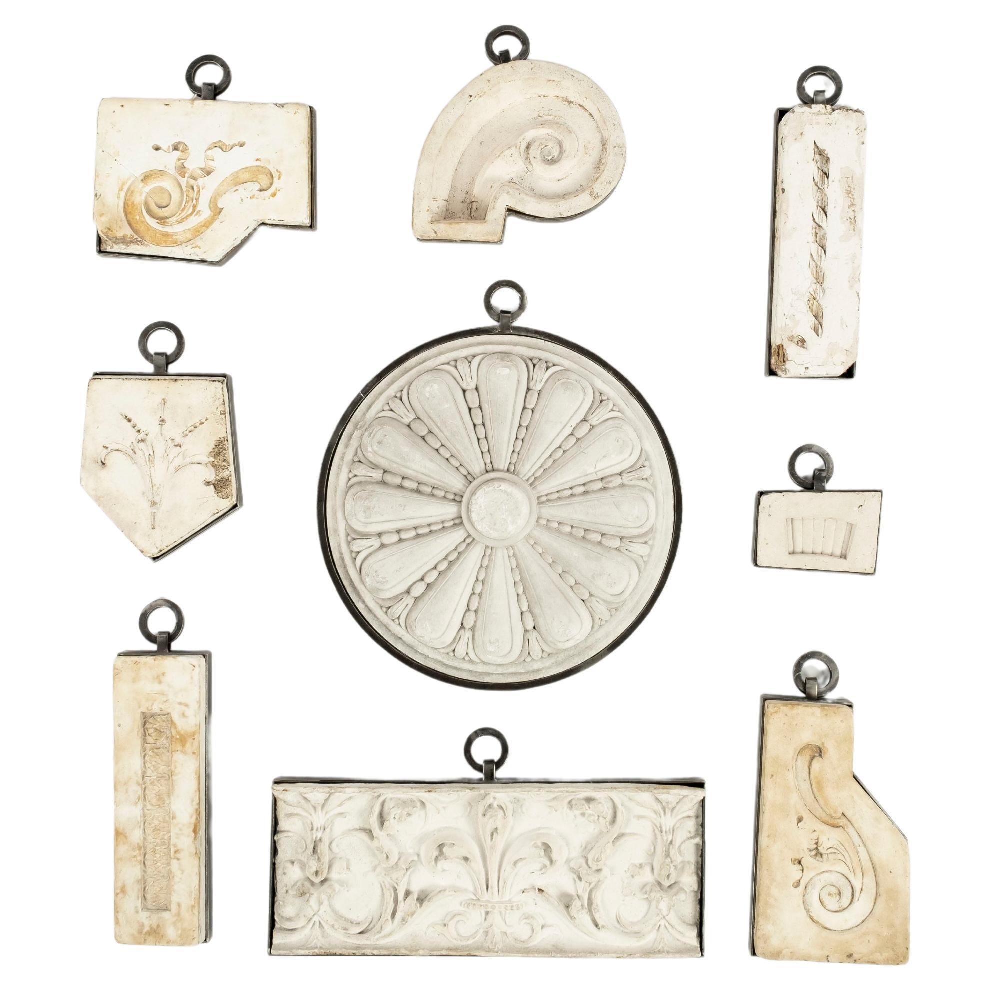 Collection de 9 fragments de plâtre architectural ancien encadrés en fer