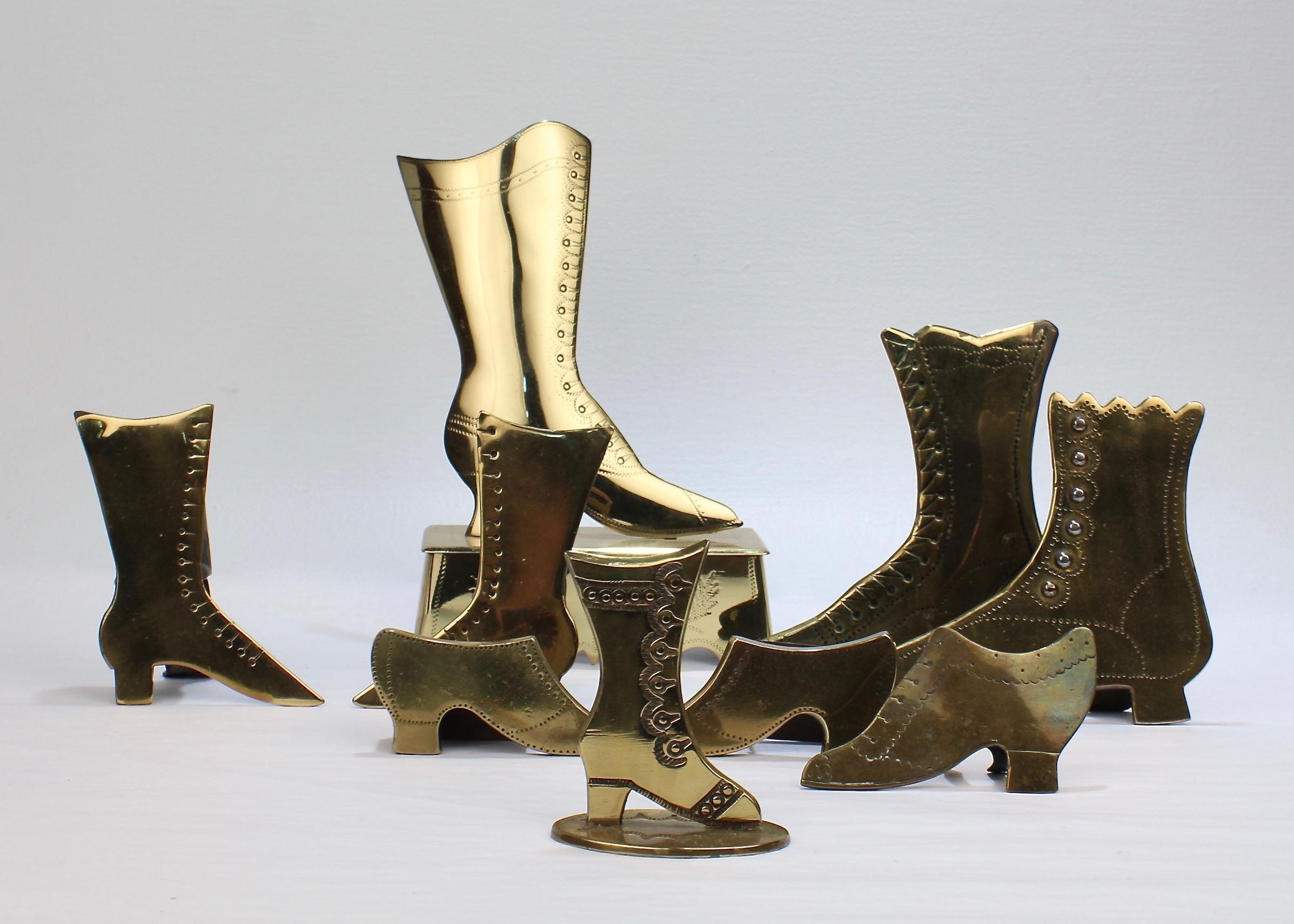 A collection of 9 brass shoe mantel ornaments.

Each in the form of a lady's boot or shoe. 

Some with applied buttons and etched decorations. 

Most have easel back stands. A few appear to possibly be matchsafes and one could double as a doorstop.