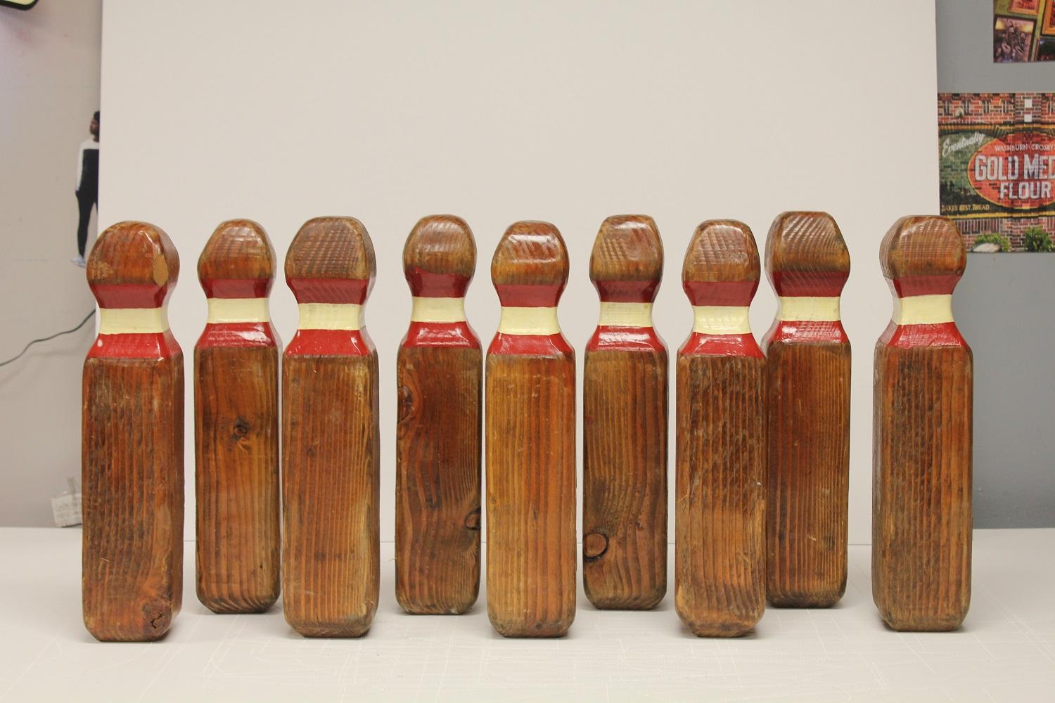 Collection of 9 vintage lawn bowling pins and one ball with original holder. Original paint.