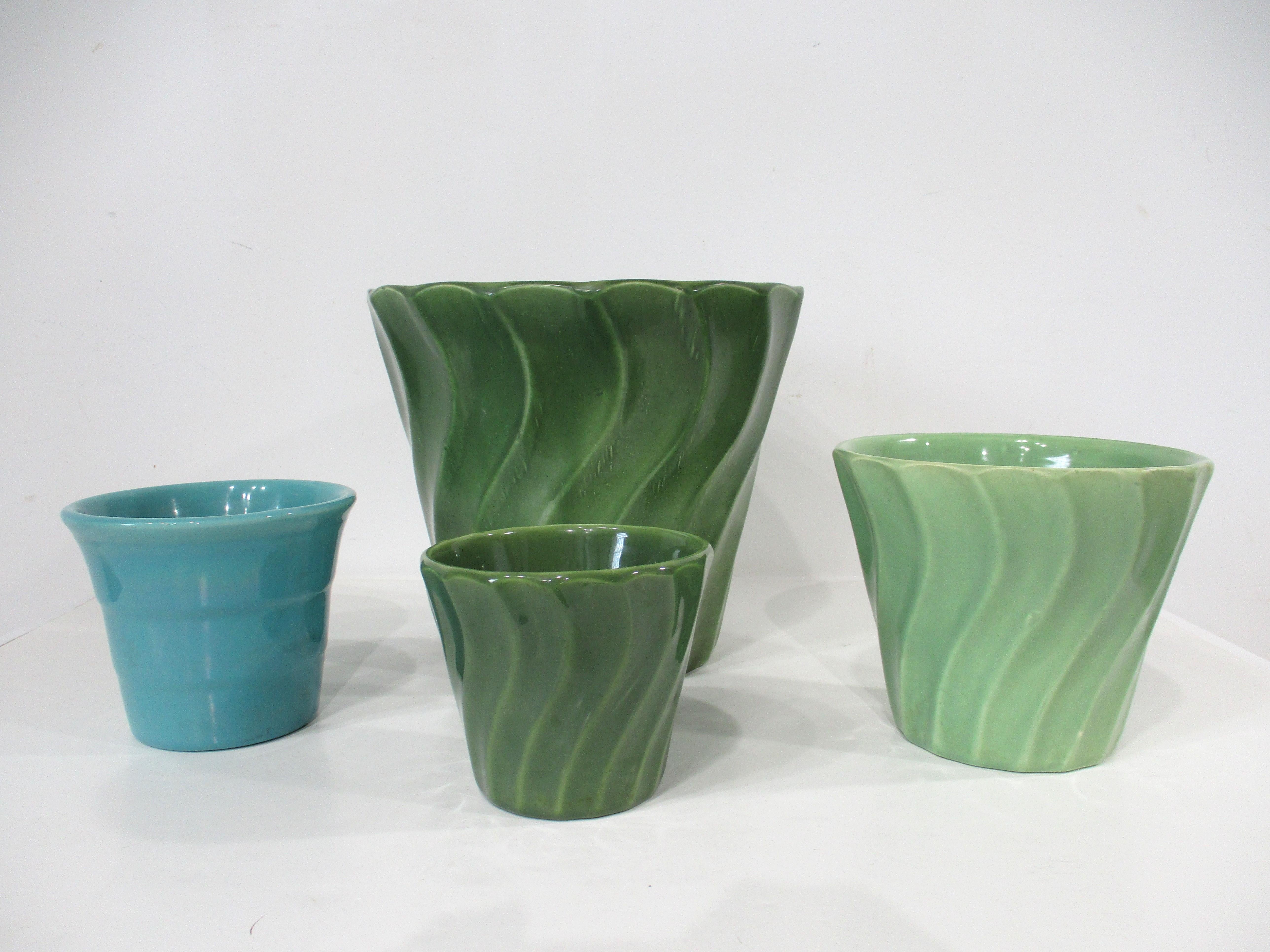 Collectional de quatre jardinières en poterie de Bauer, trois avec un motif en forme de tourbillon et une avec un côté lisse. Le plus grand est un tourbillon vert # 8 de 9,5