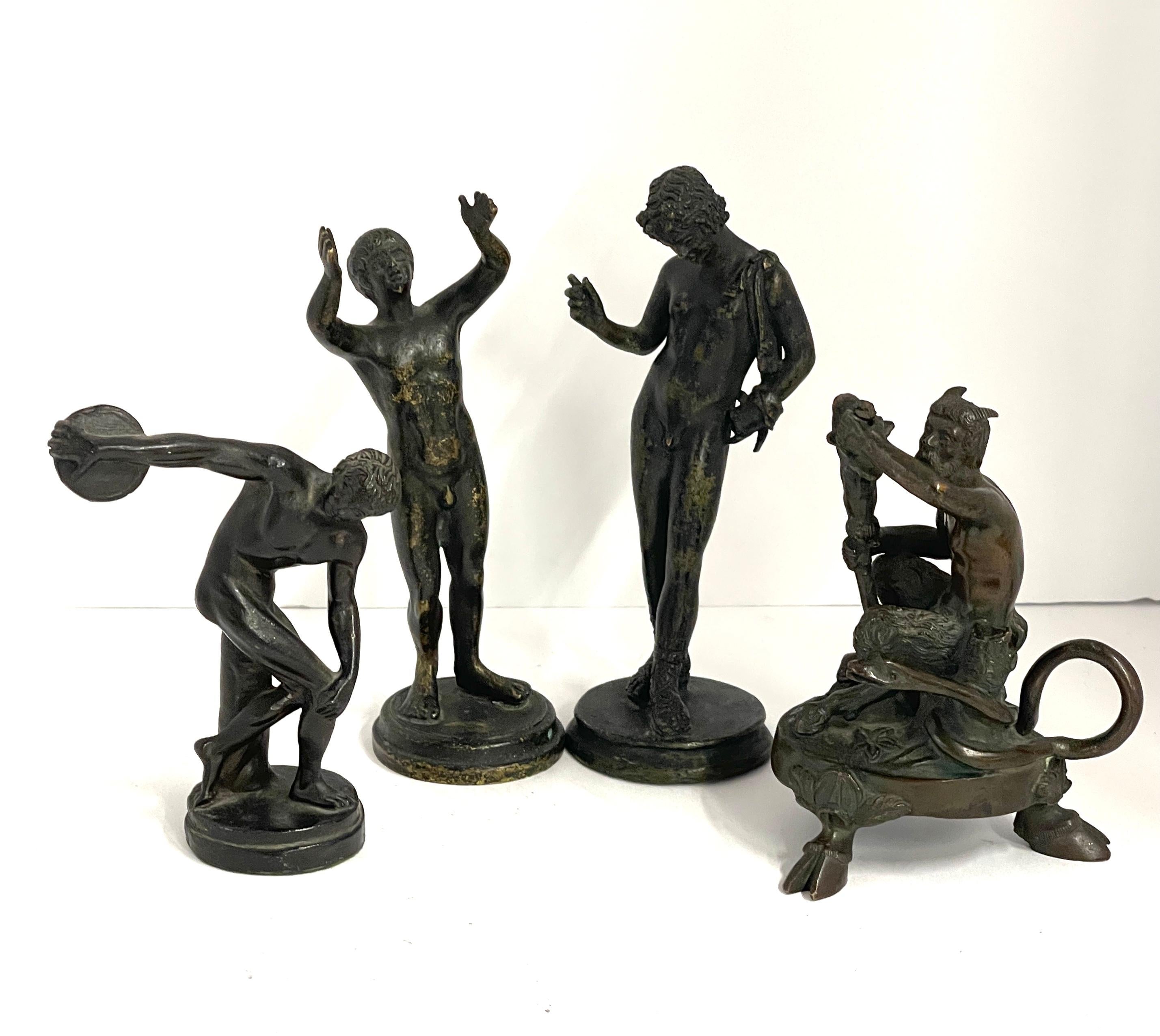 A nice collection of 4 grand tour neoclassical sculptures. There is a bronze Narcissus. A bronze satyr that was once a candlestick, missing its candle holder cup. A discus thrower, that has a weighted bottom and I'm not sure is bronze. A magnet does