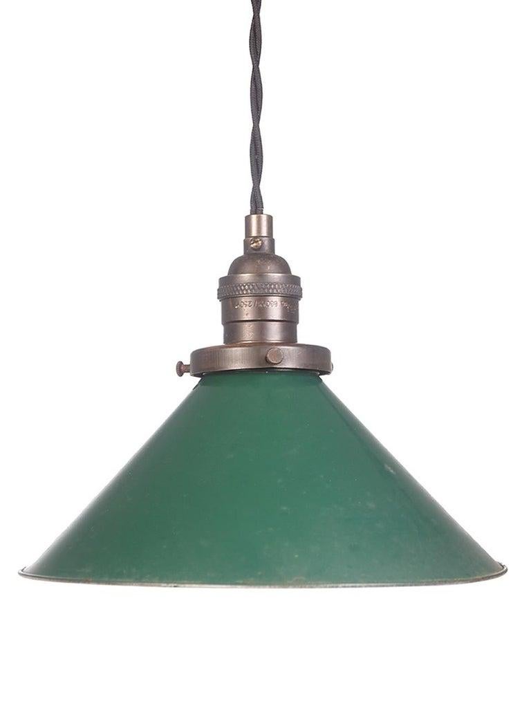 We have a nice collection of these 1930s Industrial tin pendants. The shade has the original green paint over a cream painted inside. The look is simple and clean. This is the quintessential Industrial lamp. The shades are old but were never used