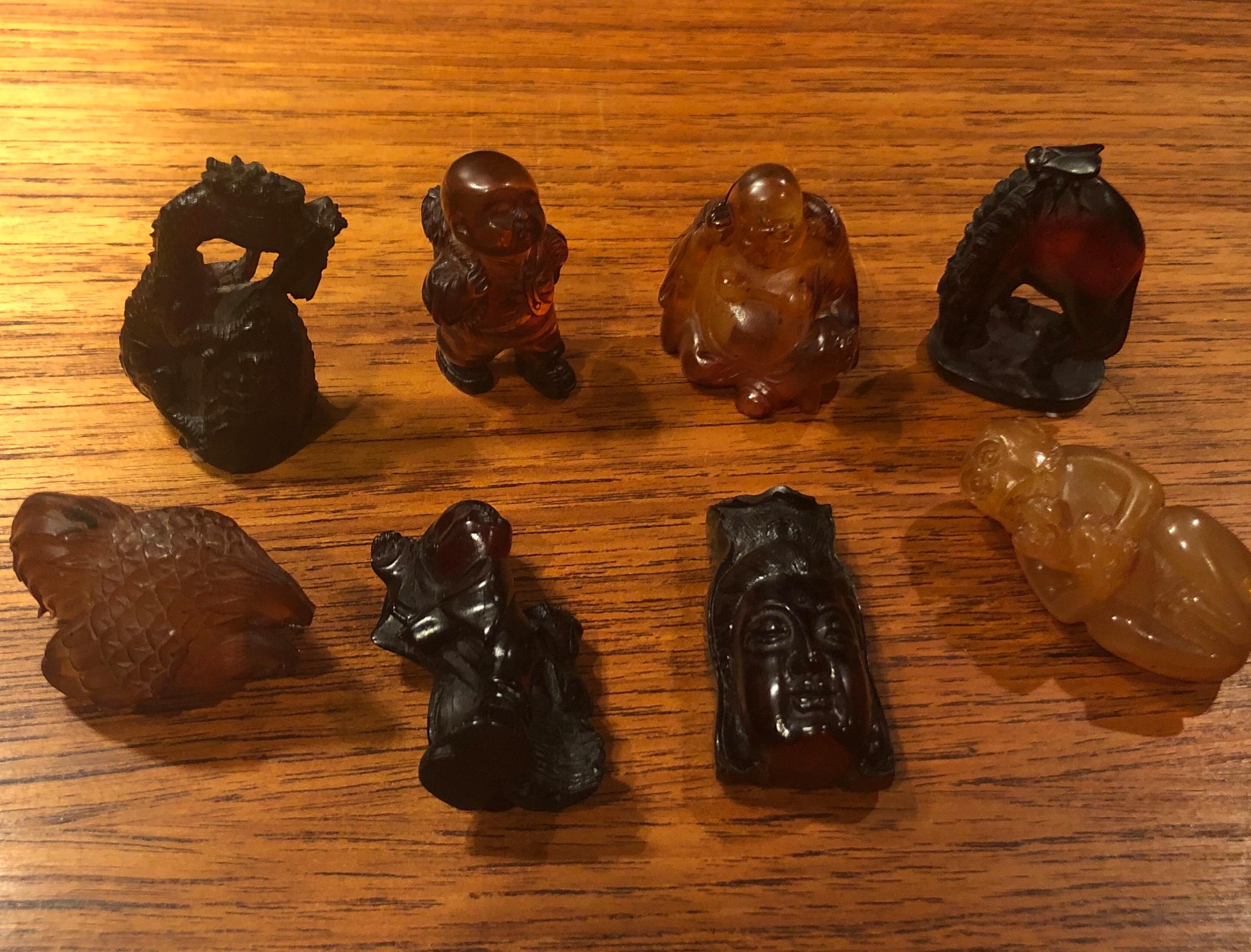 Super cool collection of eight Japanese netsukes made of either amber, resin or bakelite, circa 20th century. There are four figurative netsukes and four of the pieces are highly animals and a dragon. Some of the pieces are signed. Nice little