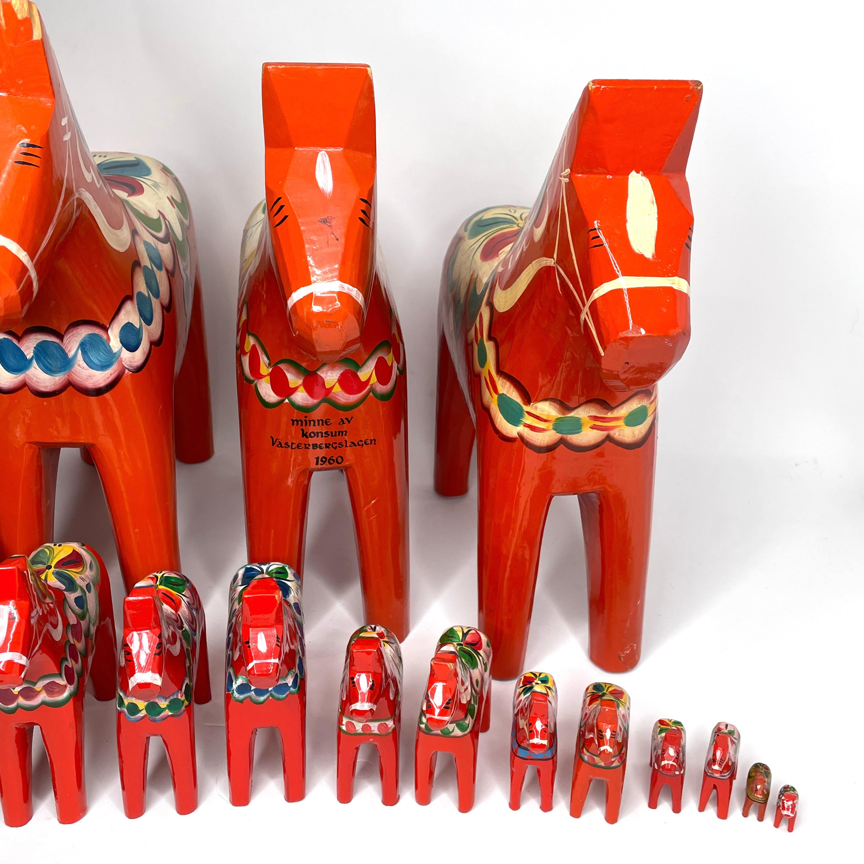 This offer is for a collection of eighteen Swedish Dala horses by Nils Olsson. These are hand carved painted wood. The largest one is approximate 16 1/2