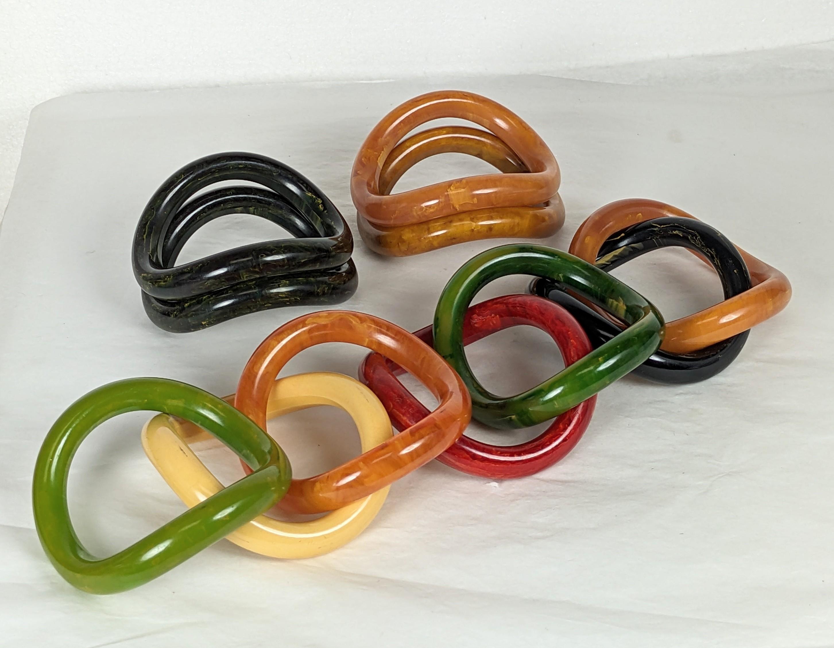 Collection of End of Day Bakelite Squiggle Bracelets from the 1960's likely made of bakelite from an earlier period. Each is shaped like a potato chip and stack perfectly on top of each other. Wonderful colorations which work beautifully in a
