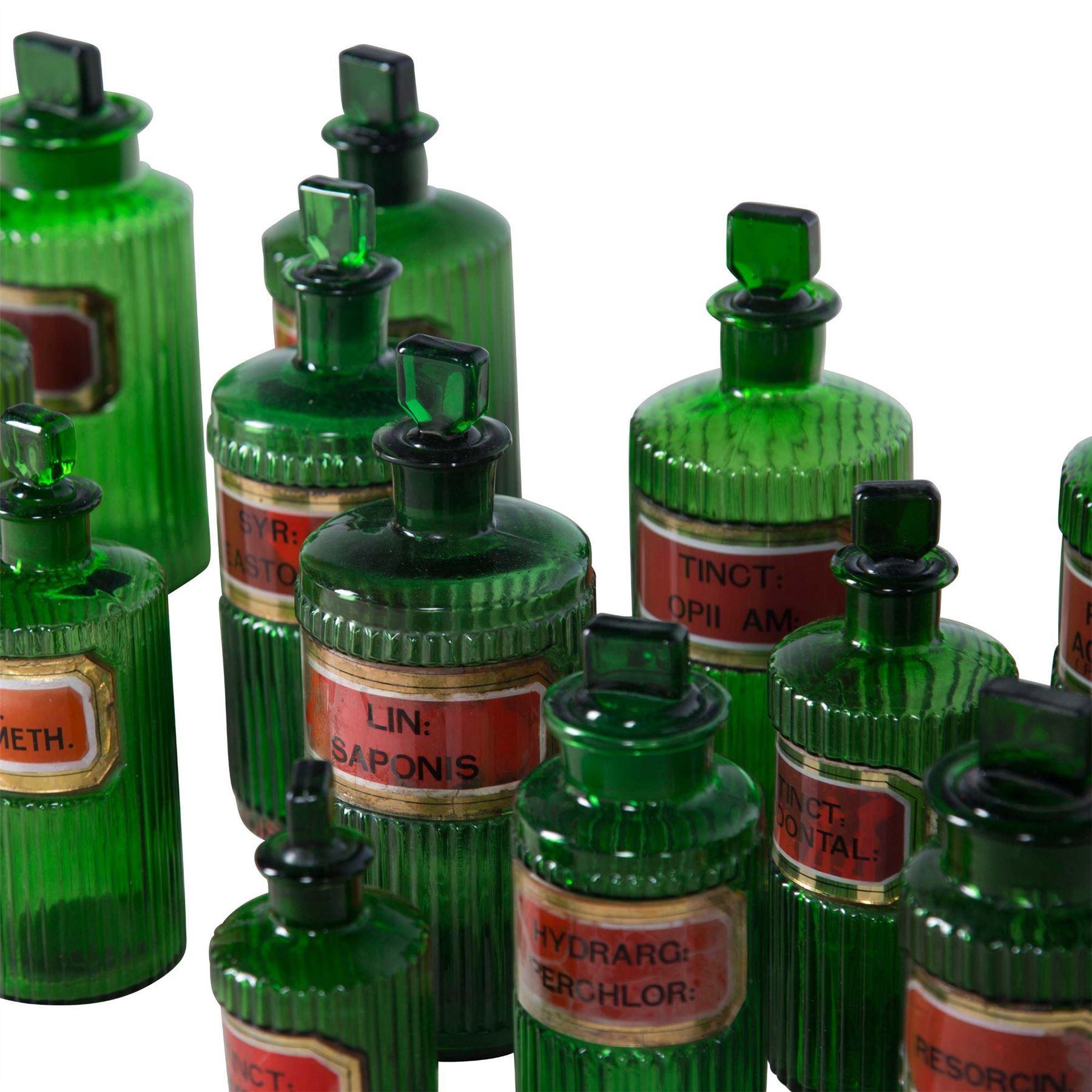Collection of English emerald green apothecary or chemist bottles, circa 1930s. Great run of seventeen bottles in very good condition with all original labels. Measurements for smaller bottles: Height 15cm, width/depth 5cm.