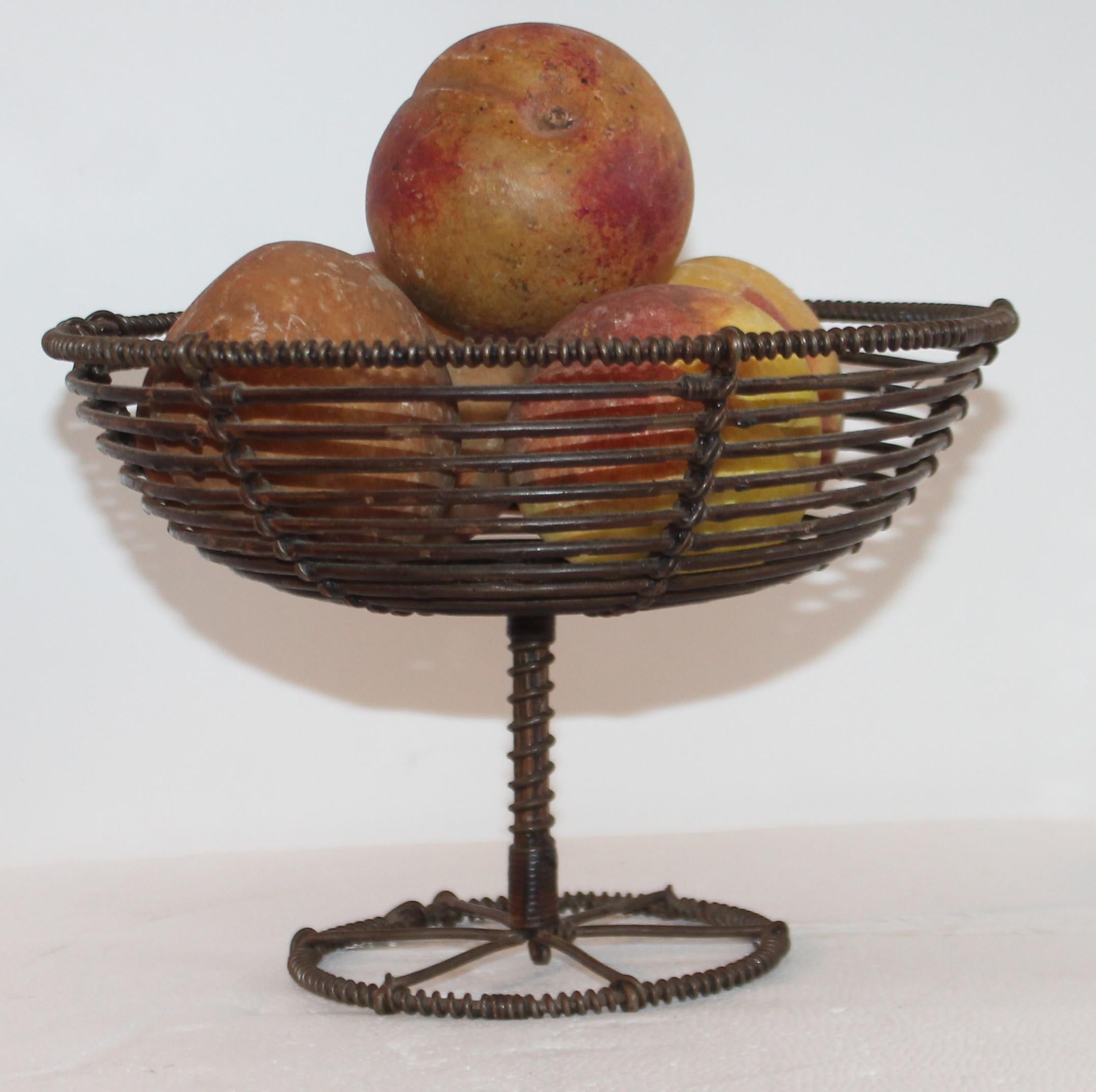 Collection of five pieces of alabaster peaches in a 19th century wire compote. The condition is very good. There are five peaches in the group.