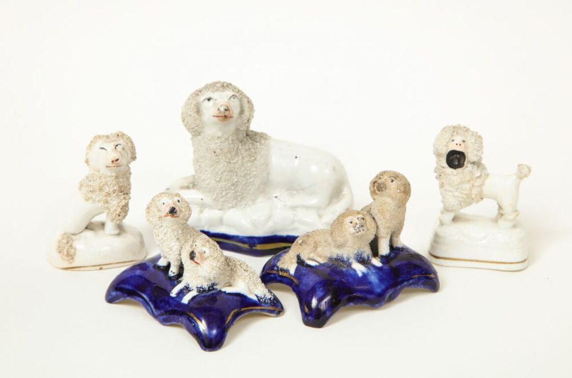Seated and standing poodles on cobalt or unglazed bases with gilt banding.