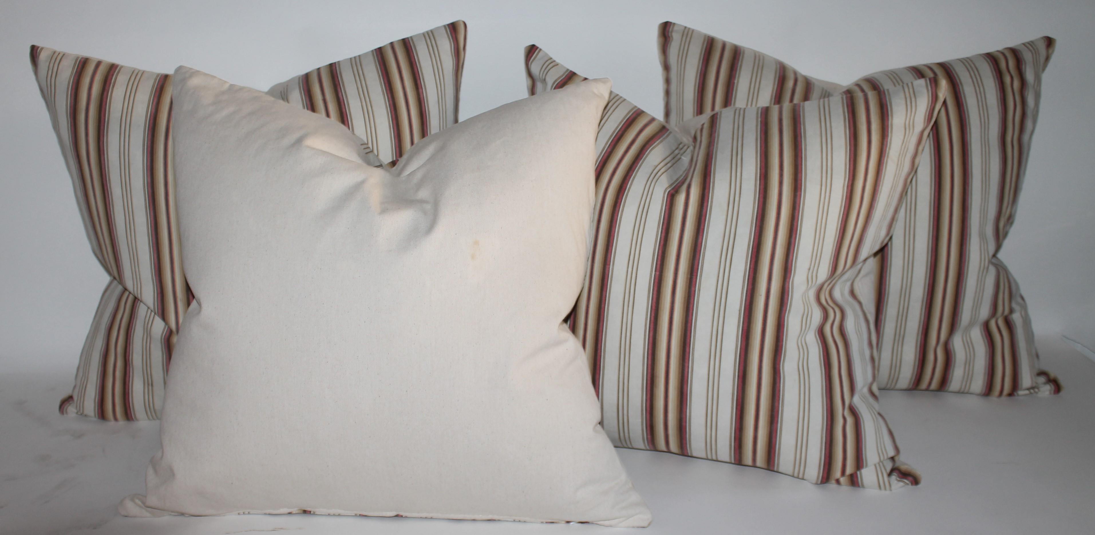 Collection of four 19thc brown & tan ticking striped pillows. Selling a pair of 20 x 20s and a pair of 22 x 22. Total of four pillows.