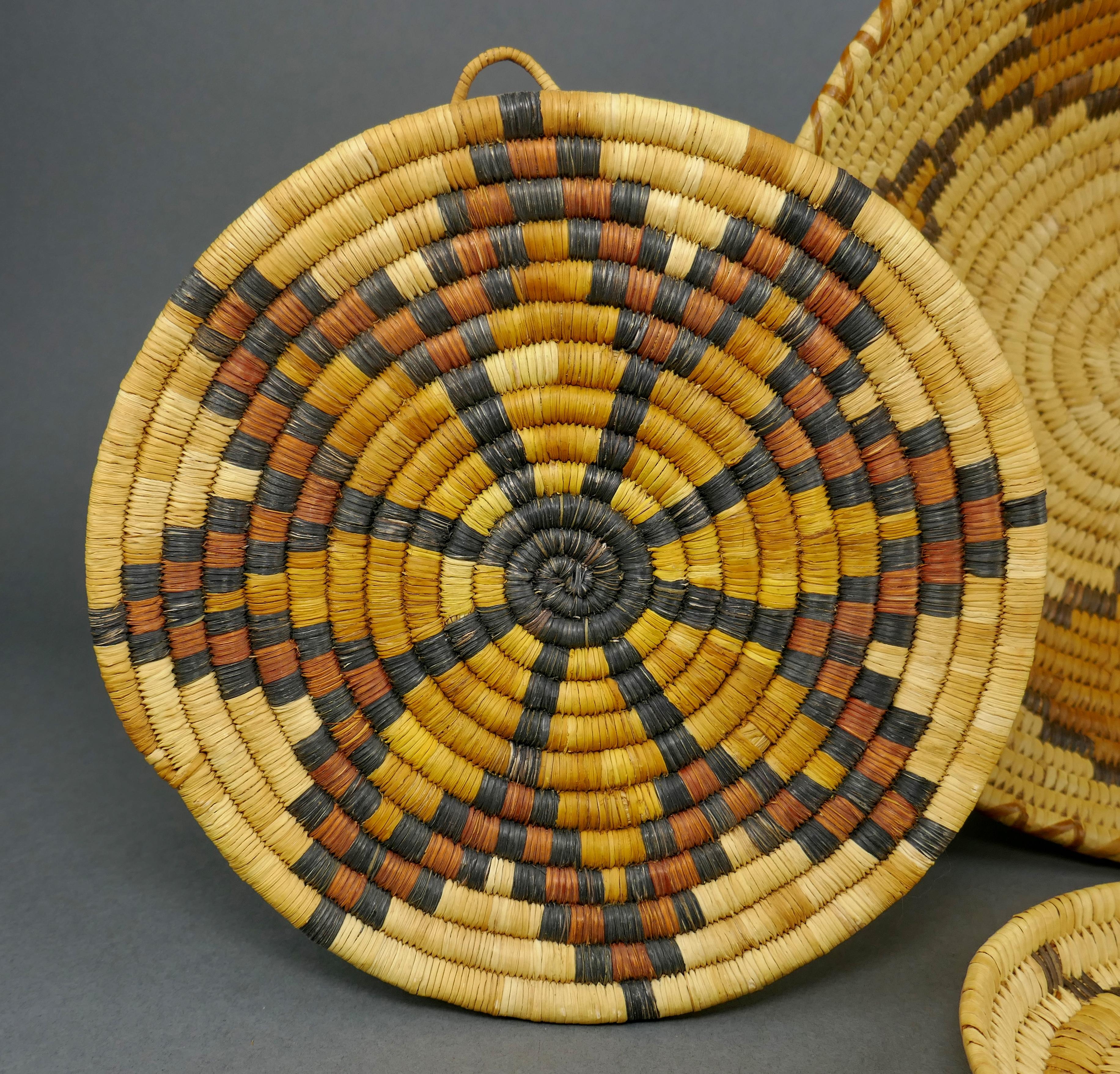 Collectional de 4 paniers amérindiens faits à la main. Trois d'entre elles sont l'œuvre d'un artiste Tohono O'odham (Papago), et le plateau de gauche, debout, est Hopi. La pièce Hopi mesure 9 1/4