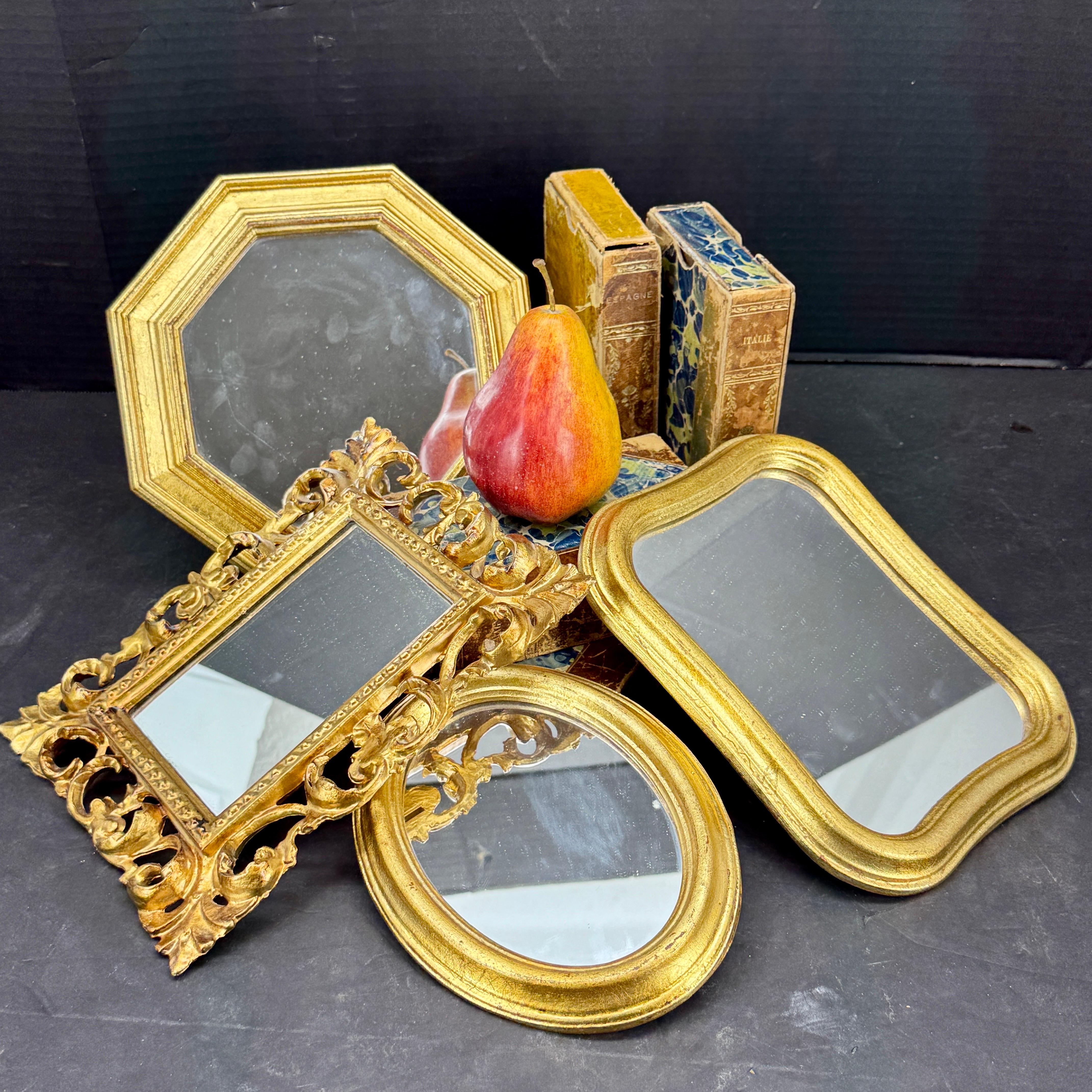 Gran agrupación de espejos dorados florentinos procedentes de Italia. Esta encantadora colección de espejos incluye tres de madera y uno de resina. Se puede utilizar en grupo o sola en una pared de galería. 