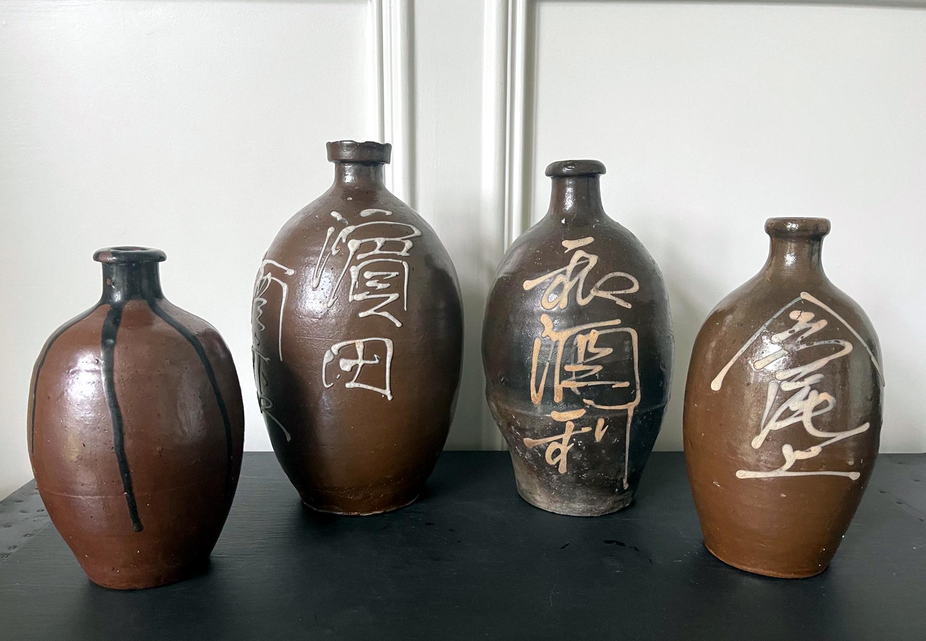 A set of four Japanese Ceramic Tokkuri Sake storage bottles circa early 20th century (Meiji to Taisho period). The bottles were made in Tamba (Tanba) kilns, located in Tachikui, Hyogo Prefecture. One of the six ancient kilns in Japan, the origin of
