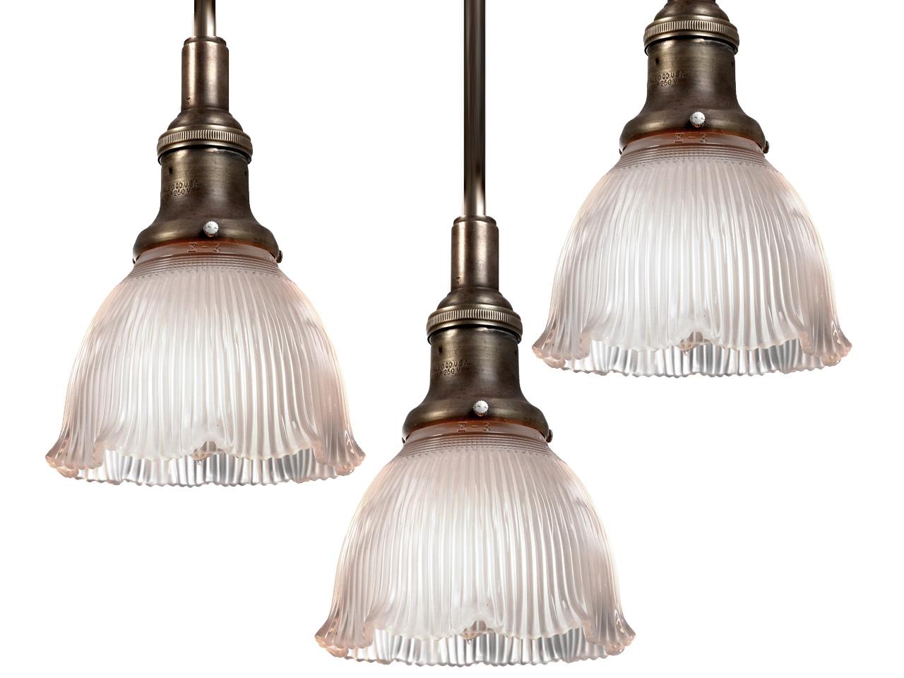 We have a collection of these small Holophane pendents. They are priced and sold per lamp. They are prismatic glass but have a soft delicate look.
The shade is frosted with a pleasing ruffled bottom edge. The socket is early and original. Its signed