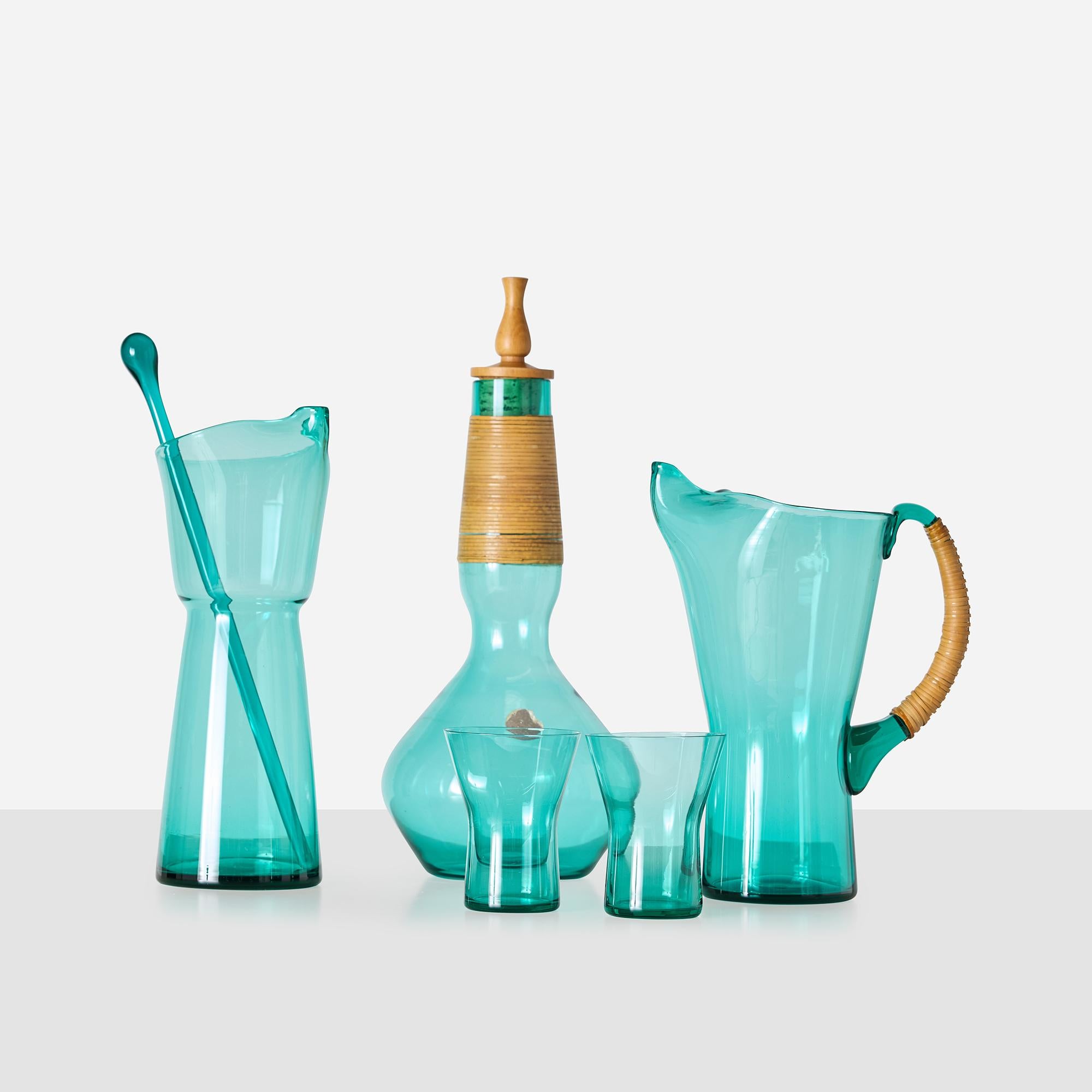 Collection of Glassware by Jacob Bang for Kastrup Glassworks

A 6-piece handblown glass set from Jacob Bang’s Grøn Serie which includes a decanter with original turned wood stopper and rattan-wrapped neck, a tall pitcher with rattan handle, 
a