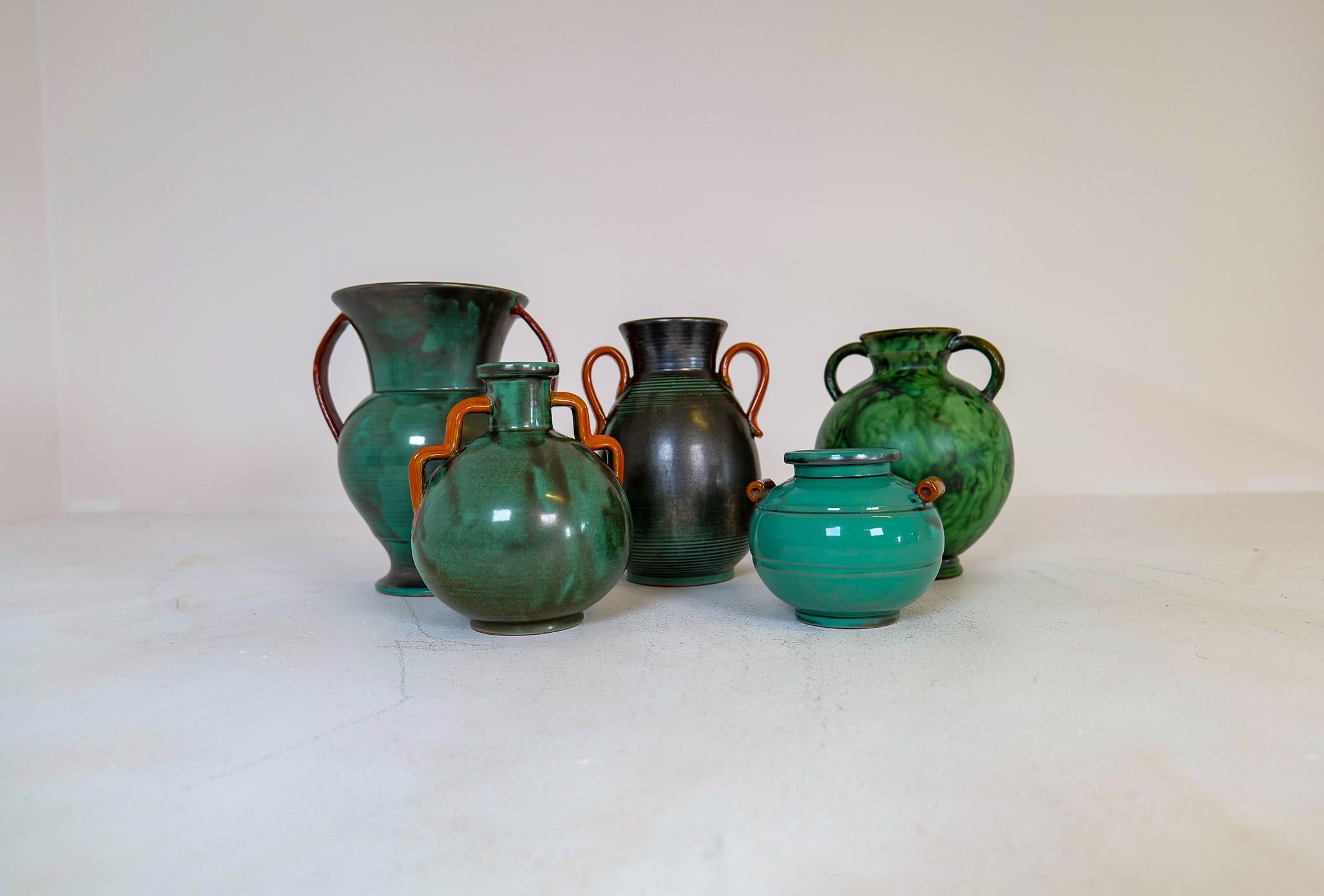 Cette collection de 5 vases Art Déco verts a été fabriquée en Suède dans les années 1930-1940.
Les formes combinées aux couleurs vertes de ces pièces donnent un aspect art déco authentique.

Bon état général, certains avec de petits défauts.