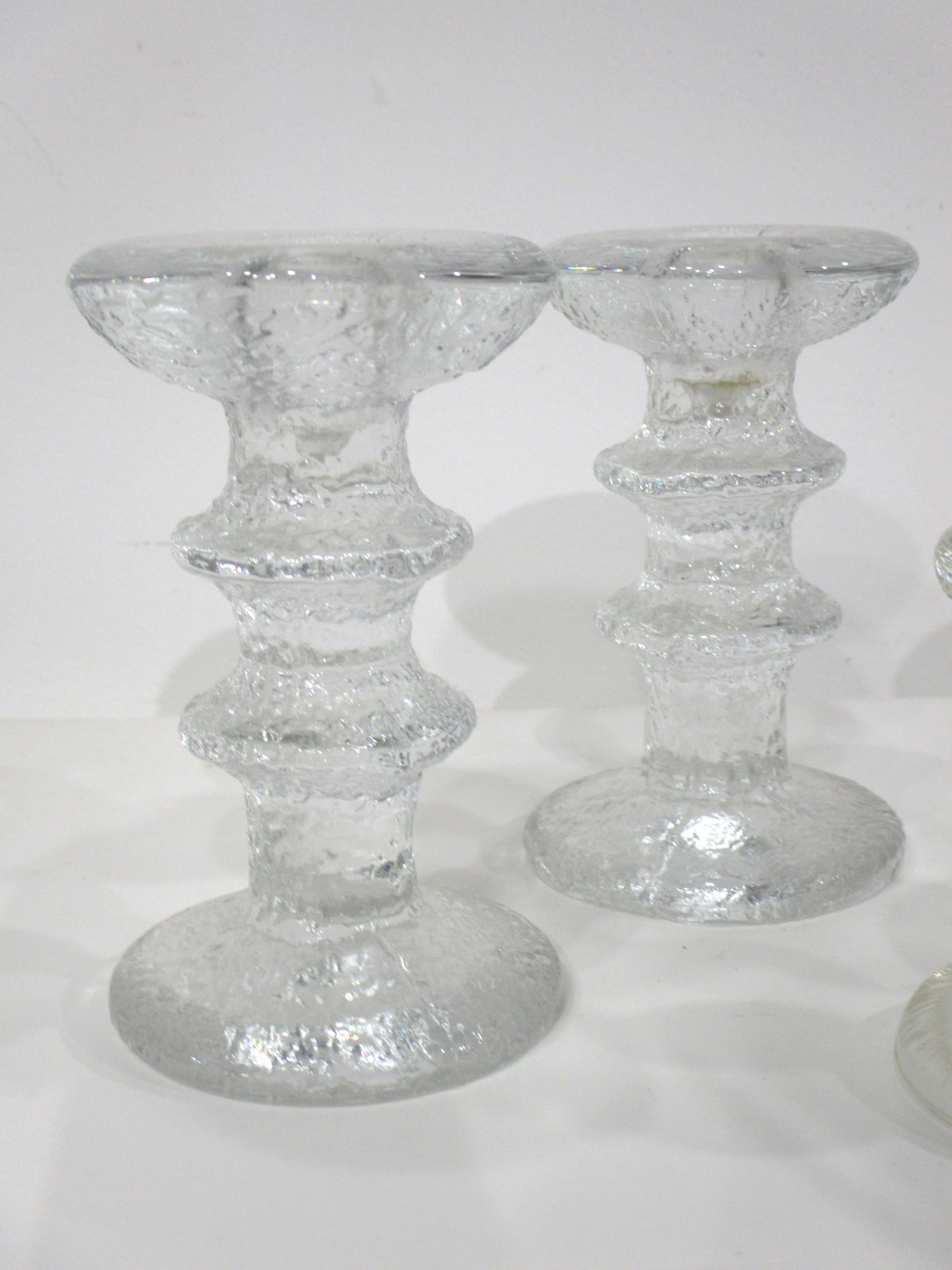 A set of four cast ice glass candlesticks two larger matching pair 5
