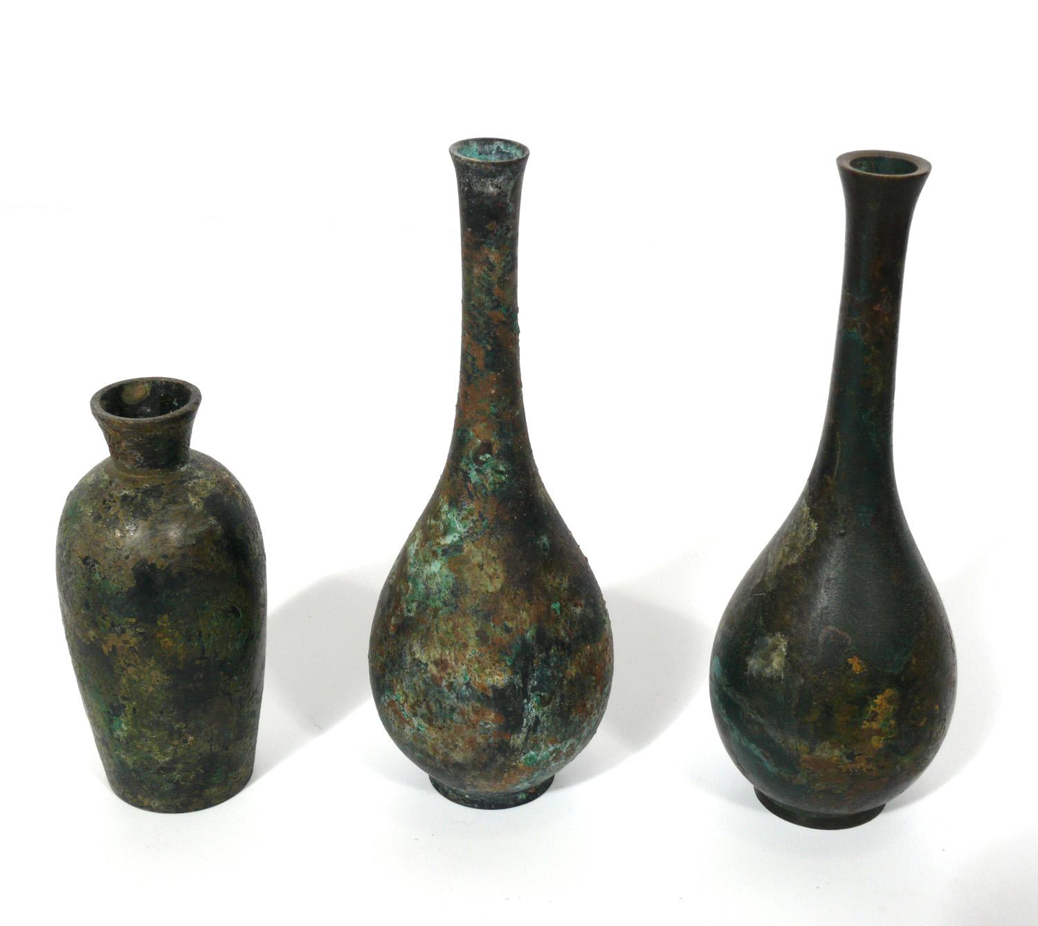 Collection of ten Japanese bronze vases, Japan, 20th century. They all exhibit sculptural forms and have a wide range of patinas from deep browns to warty verdigris greens. The largest measures 9