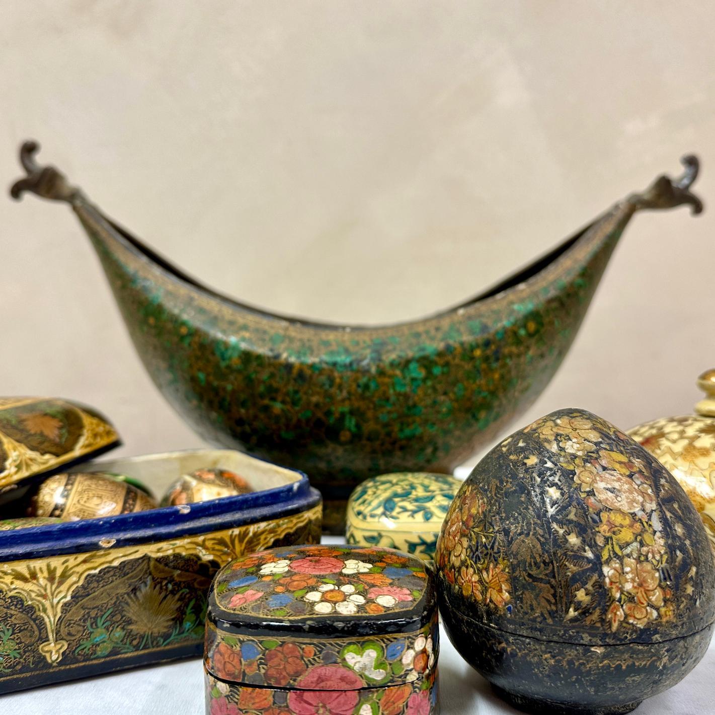 Collection of c1900-1950's paper mache trinket boxes and objects from Kashmir, to include:
Hand painted 
Brass / papier mache Beggars Bowl
8 Decorative Eggs 
Large papier mache Box
4 small Trinket Boxes

Sizes vary:
Beggars Bowl - Length - 40
