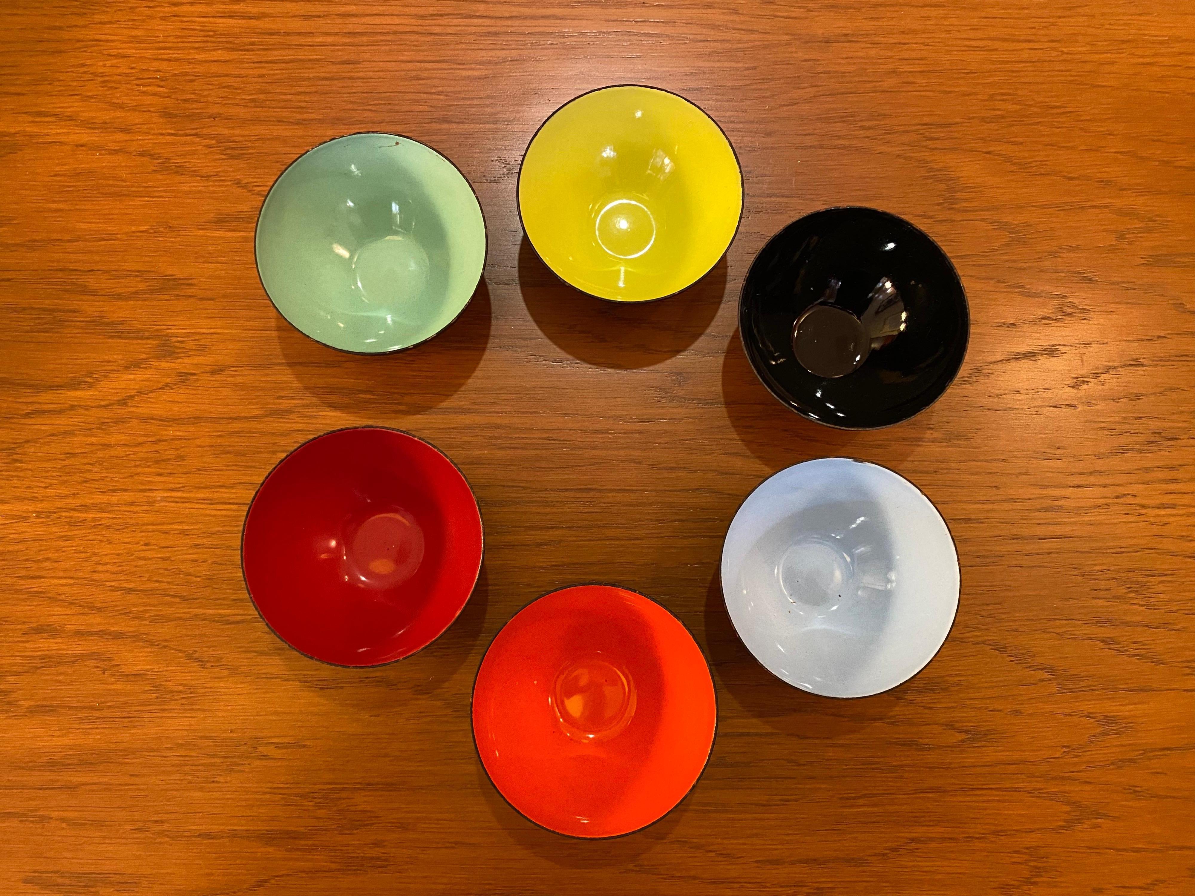 Krenit bowls are icons of Danish modern design. Designed by Herbert Krenchel. Beautiful black matt metal bowls with multi-colored insides. 12 pieces total: ((1) 11