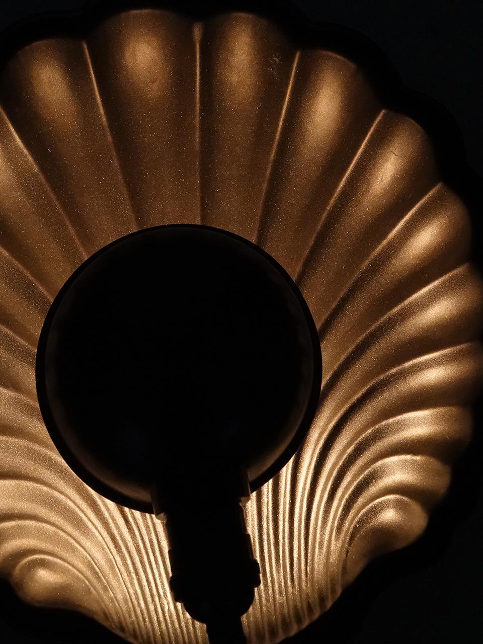 This is an impressive sconce having a 12 inch diameter. The shade is deeply stamped brass in the shape of a scallop shell. The smaller half sphere shade hold an E26 bulb and casts a dramatic indirect light that highlights the shell pattern. The