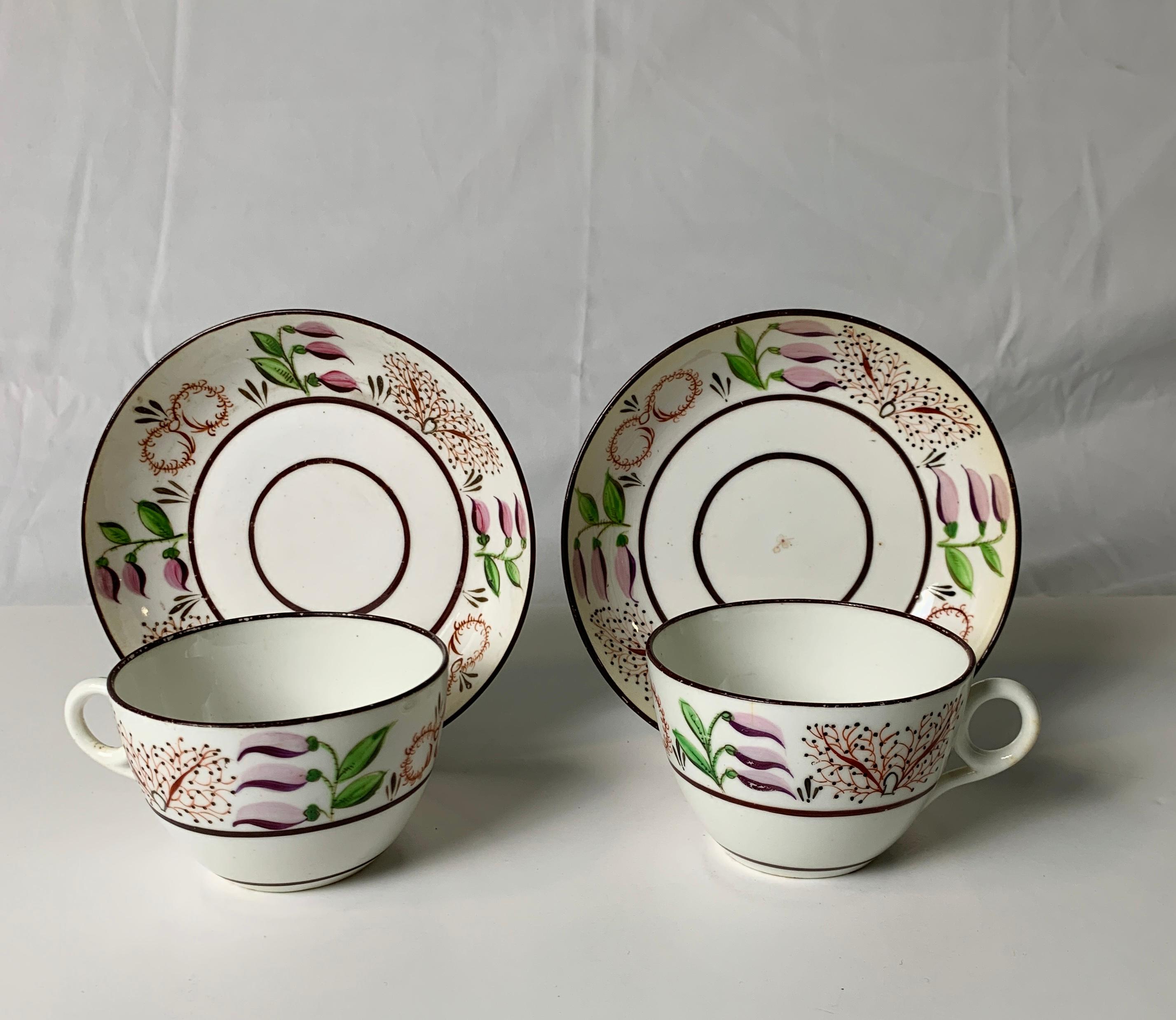 Provenance: The Private Collection of Mario Buatta a pair of porcelain teacups made in England, circa 1825.
This lovely pair of Staffordshire teacups is painted with a delicate floral design featuring lavender-pink buds, green leaves, and red vines