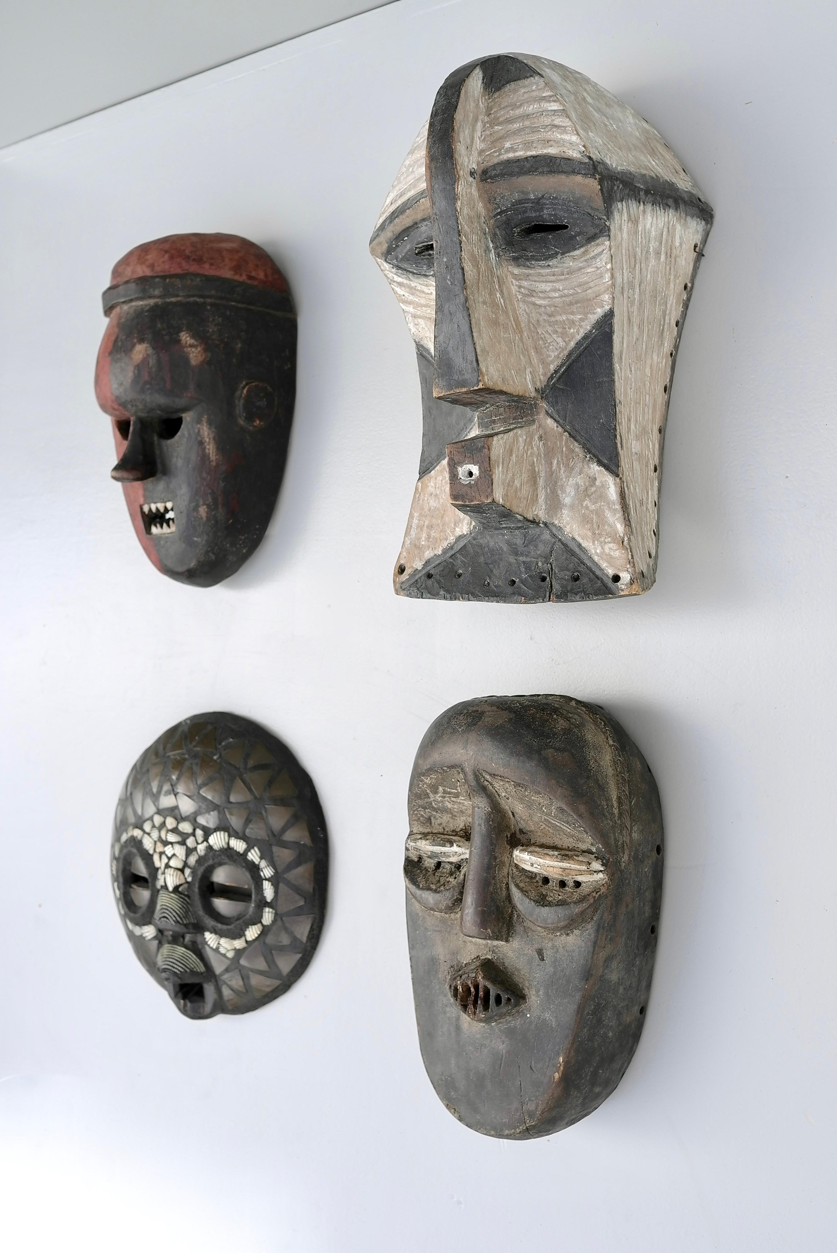 Collection of midcentury African multicolored wooden masks.

Red/brown 30cmx18cmx 12cm
Black/white 38cmx19cmx20cm
Brown 30cmx17cmx10cm
Brown/shell brass dia 28cm x6cm
